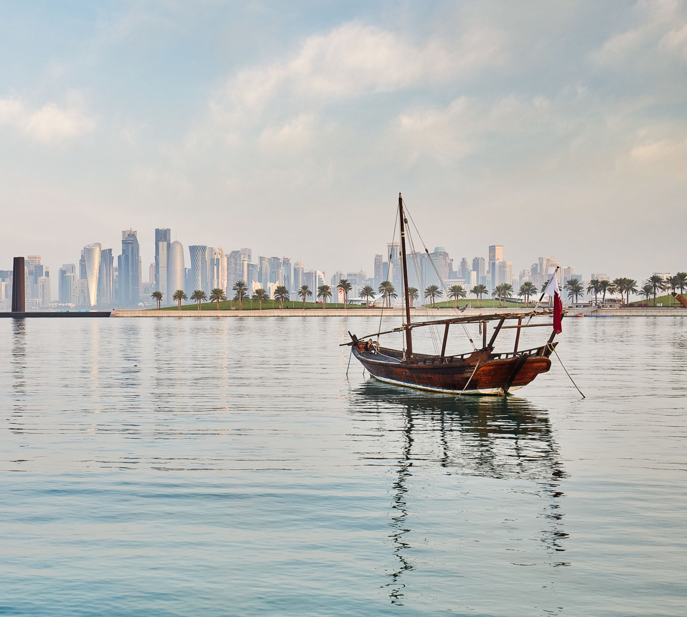 Dhow boat on the water with the city in the background.