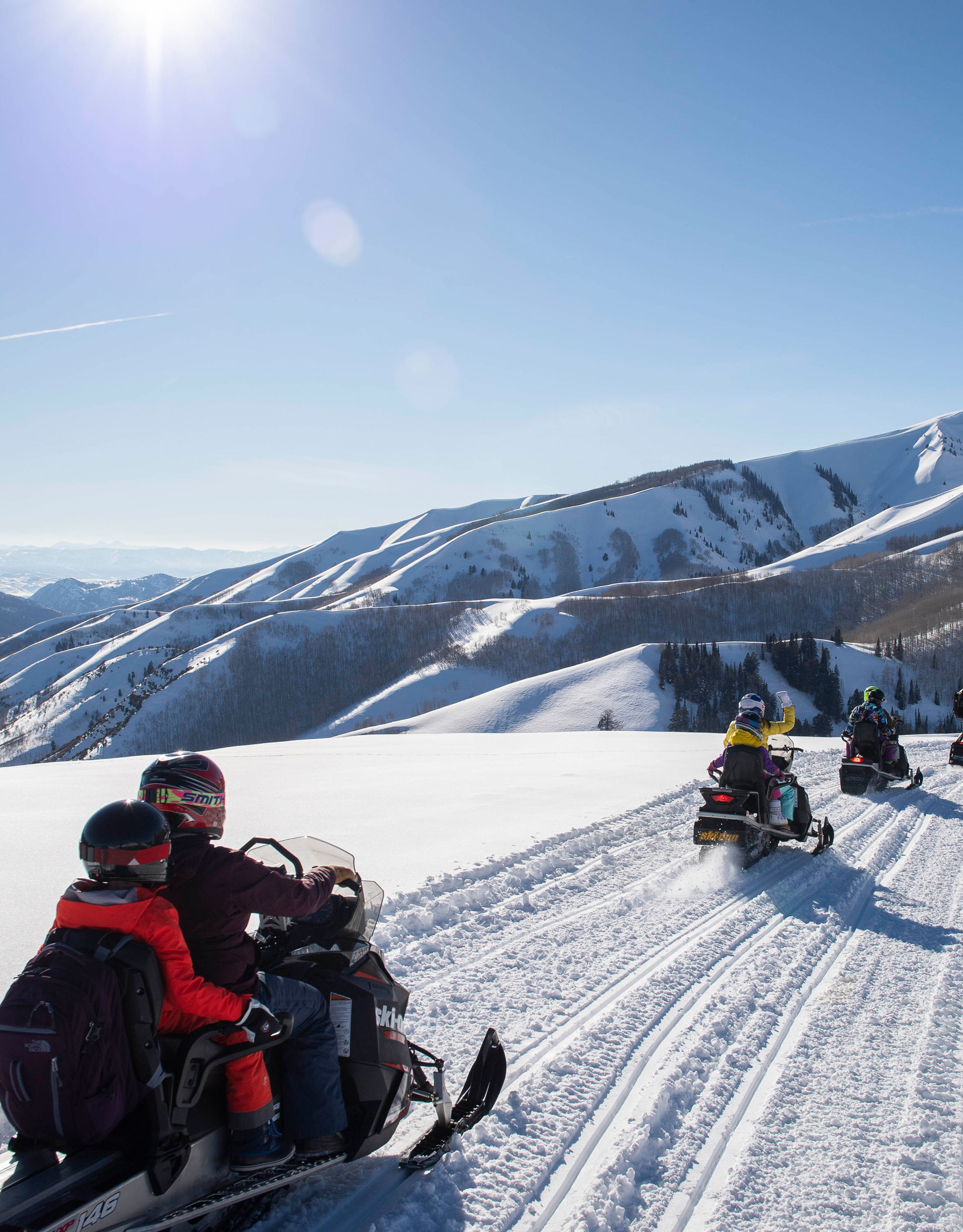 People Riding Snowmobiles on a Mountain