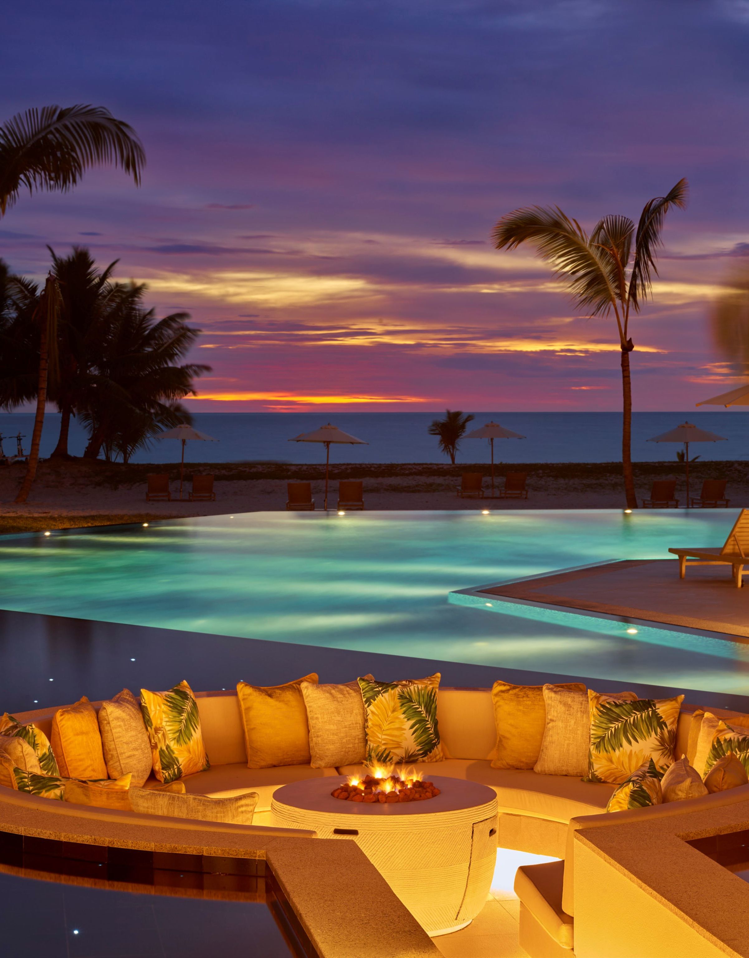 night time shot of pool with ocean in background