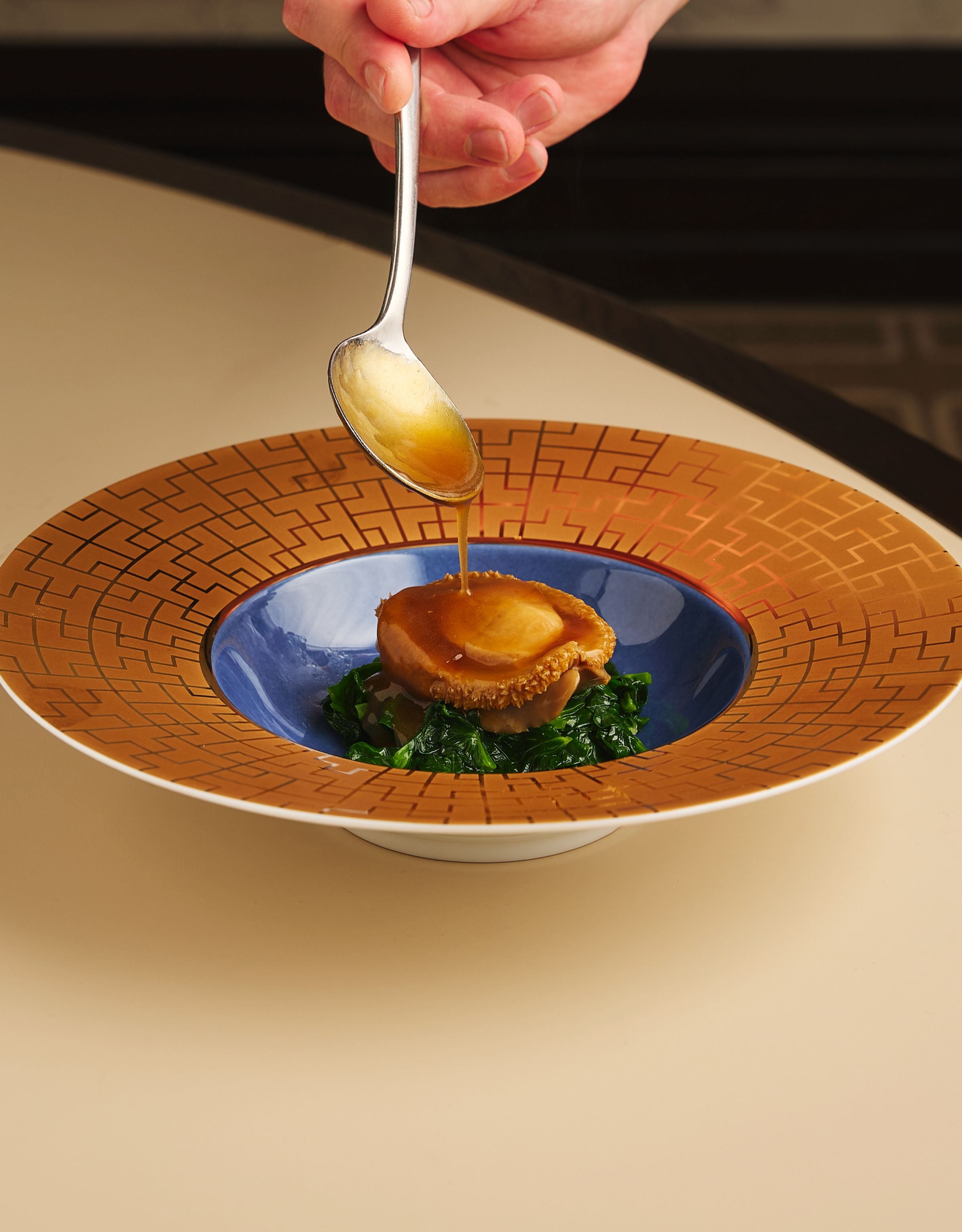 Summer Palace image, with chef spooning sauce onto plate