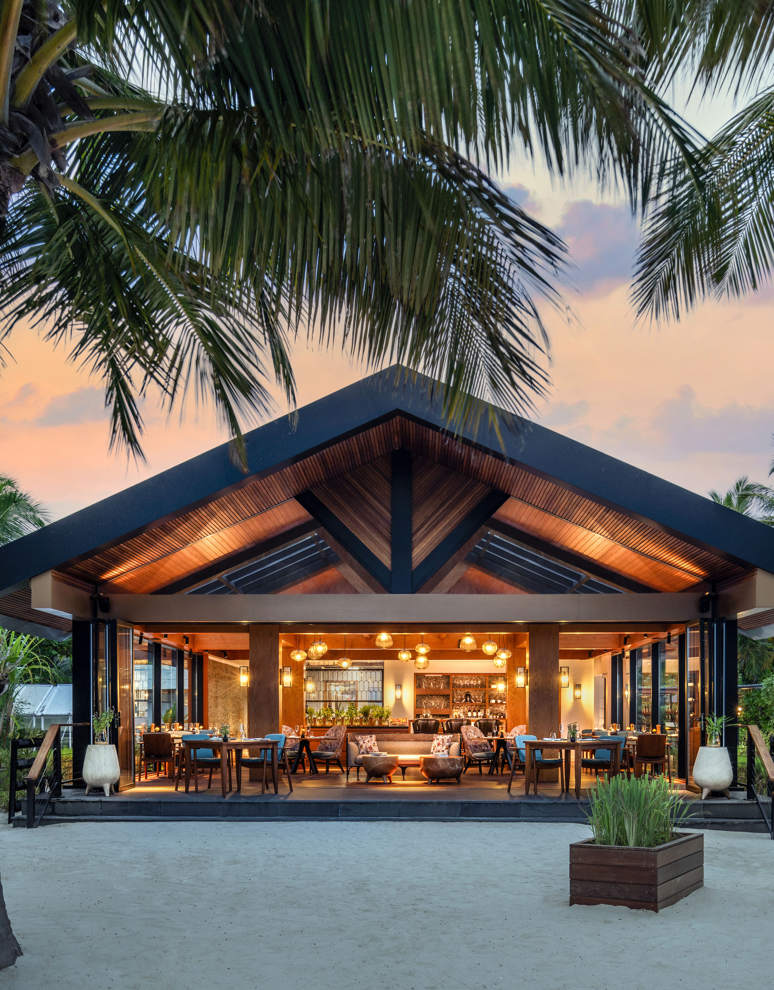 Exterior View of the The Ledge Restaurant at Sunset with Palm Trees