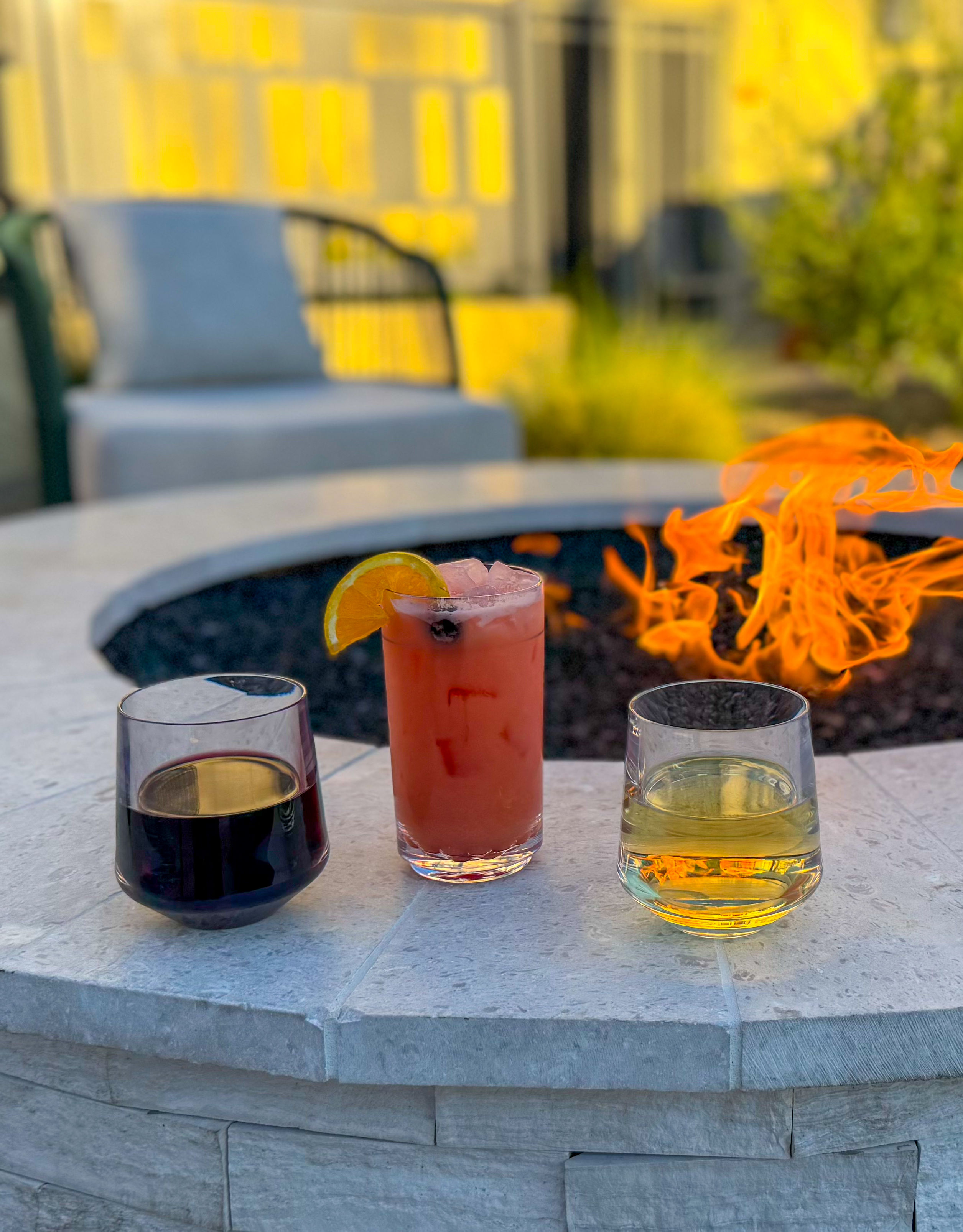 Cocktails sitting on the edge of the firepit on the patio.