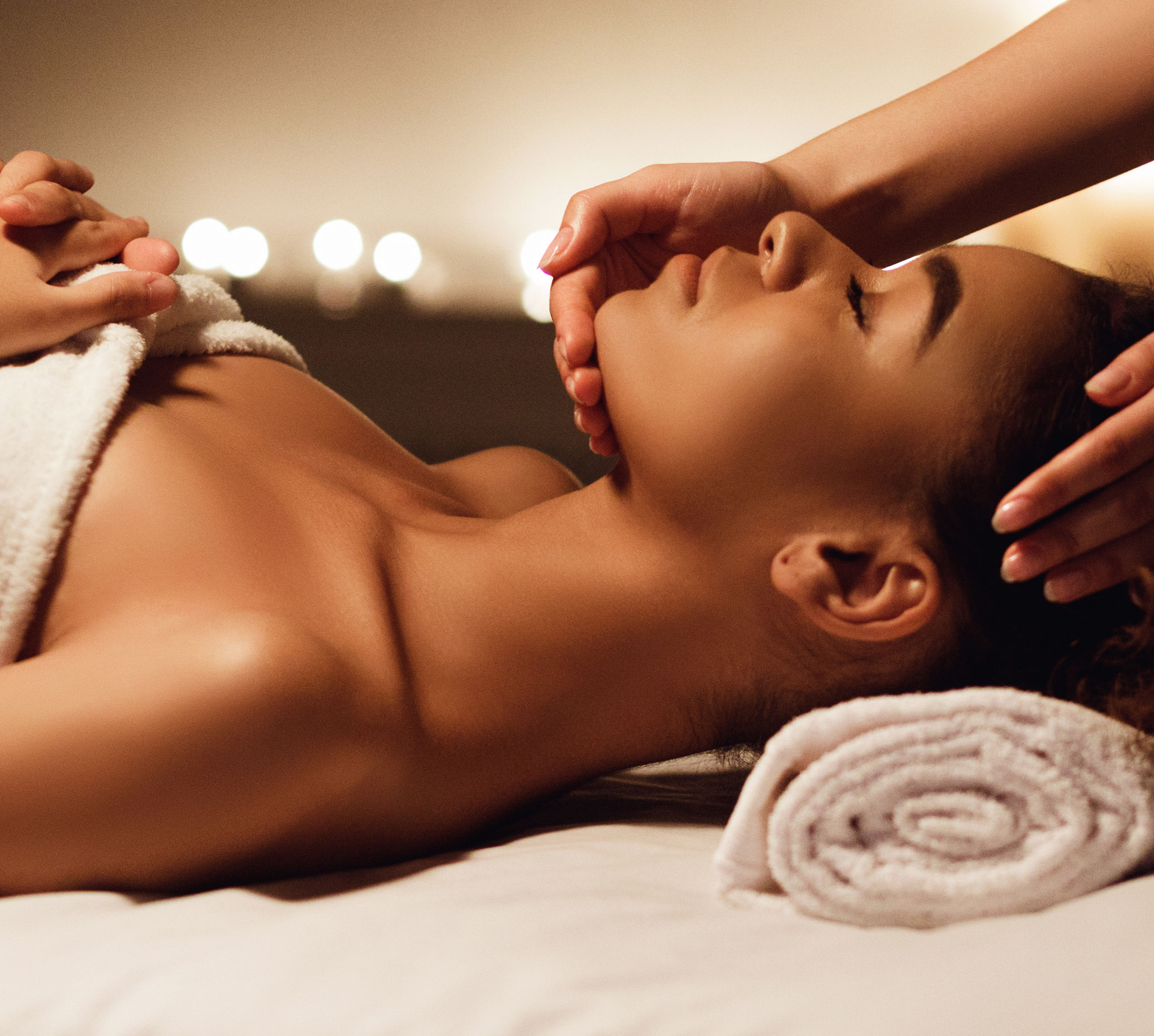 Woman lying on a treatment bed enjoying a facial