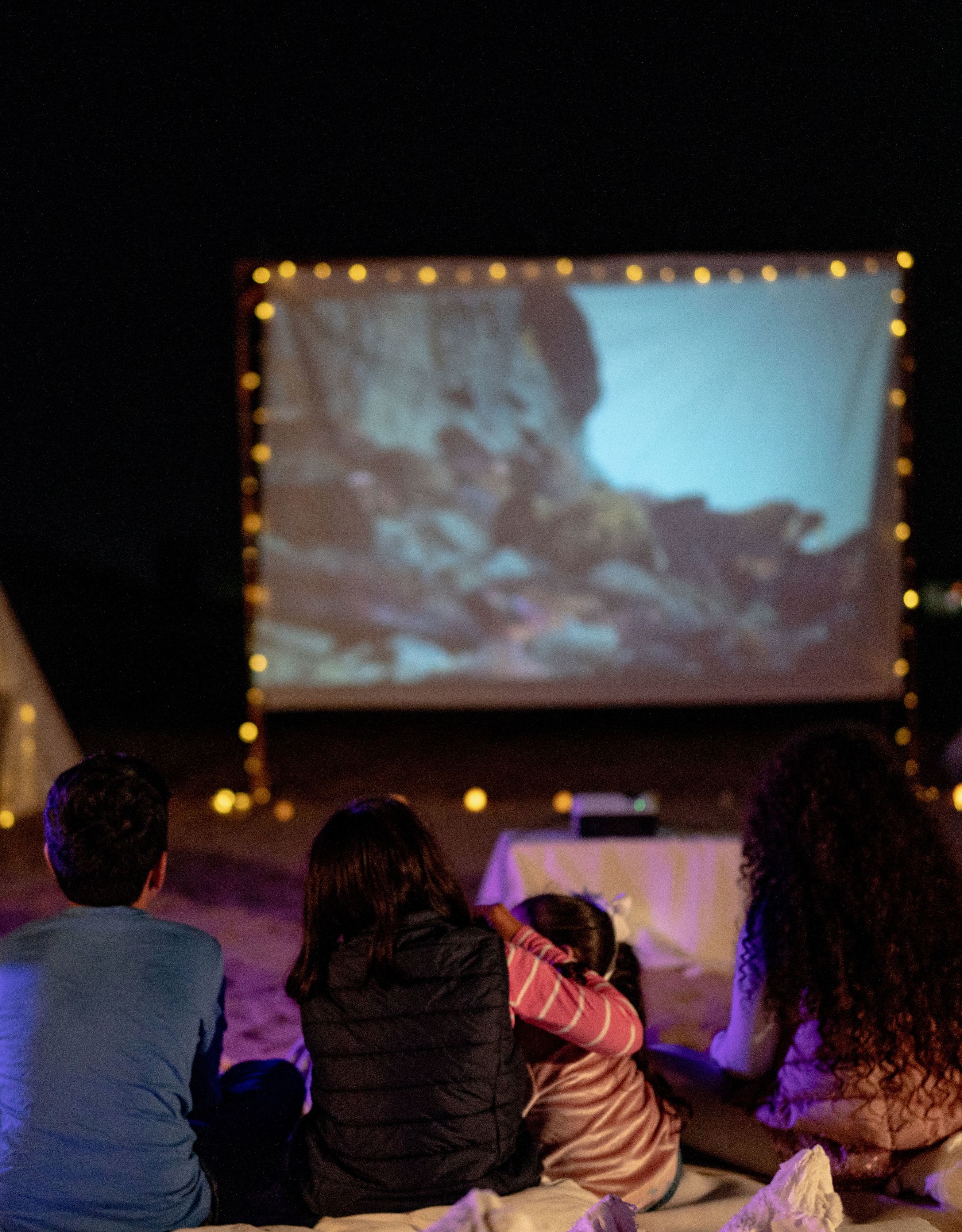 People Watching a Movie Outdoors at Night