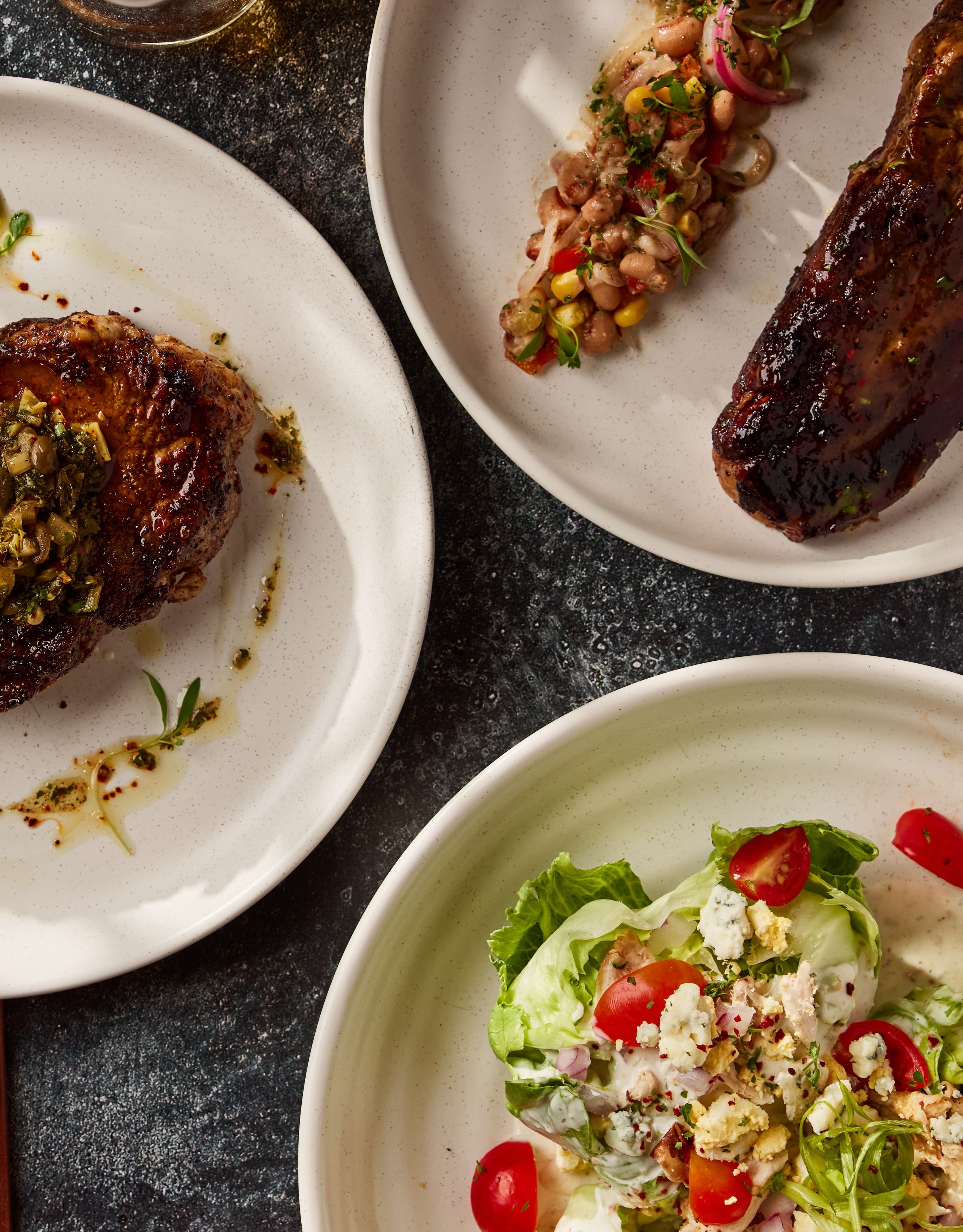 Close up of several barbequed meats at salads at the Cannon + Belle Restaurant