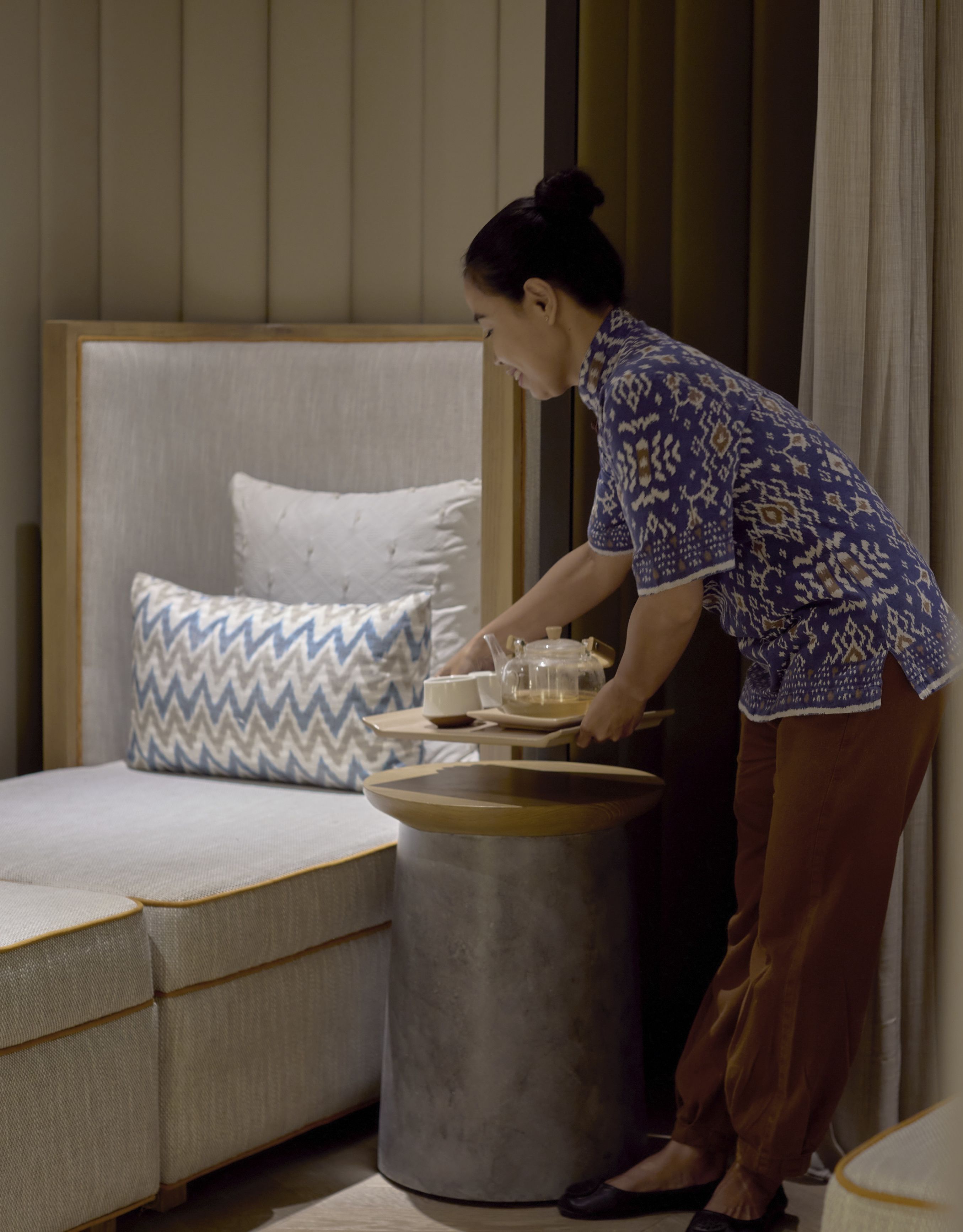 Anggota staf menempatkan nampan di area duduk yang nyaman