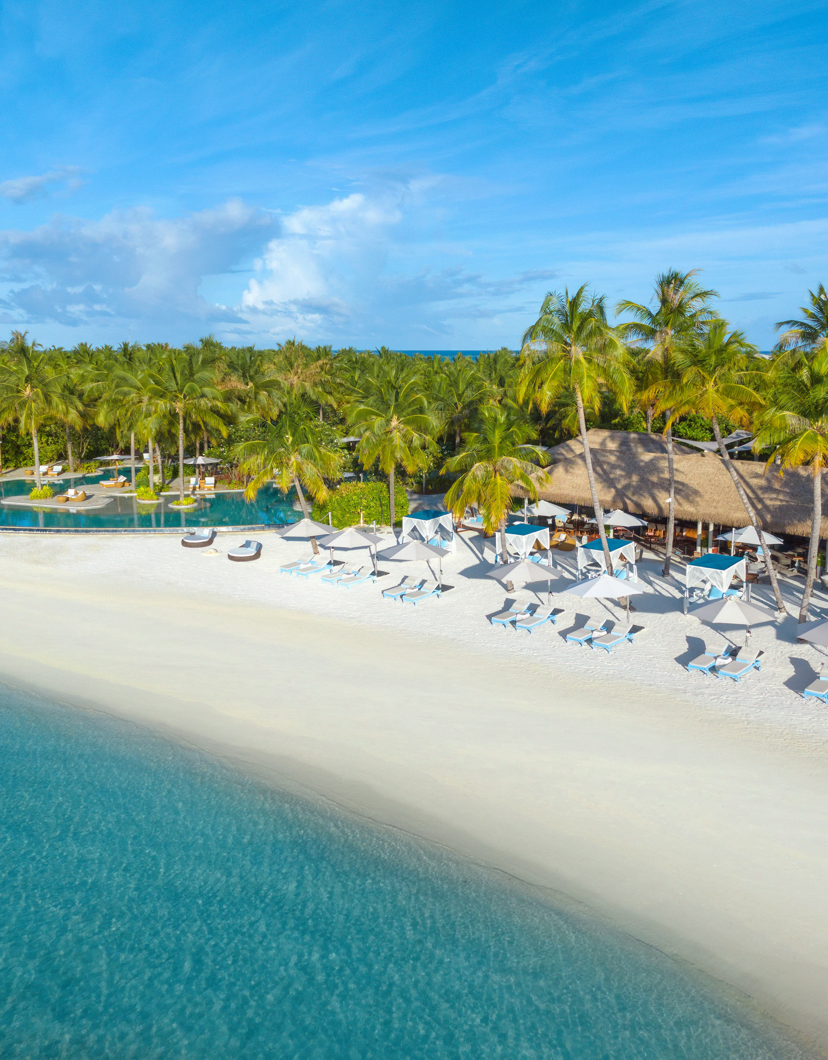 View of Nava Beach with Lounge Chairs and Palm Trees