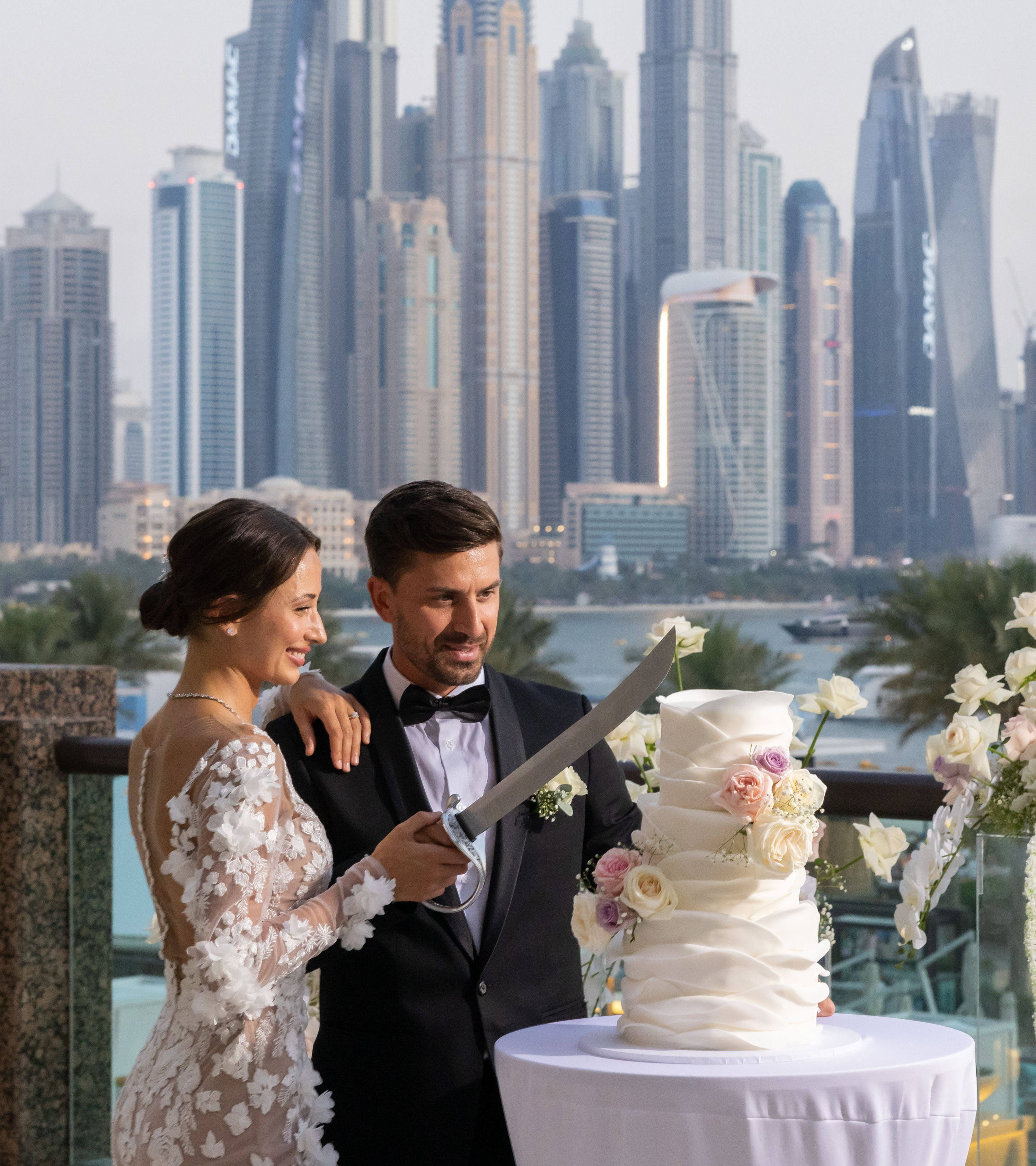 Bruiloftspaar snijdt bruidstaart met stad op de achtergrond