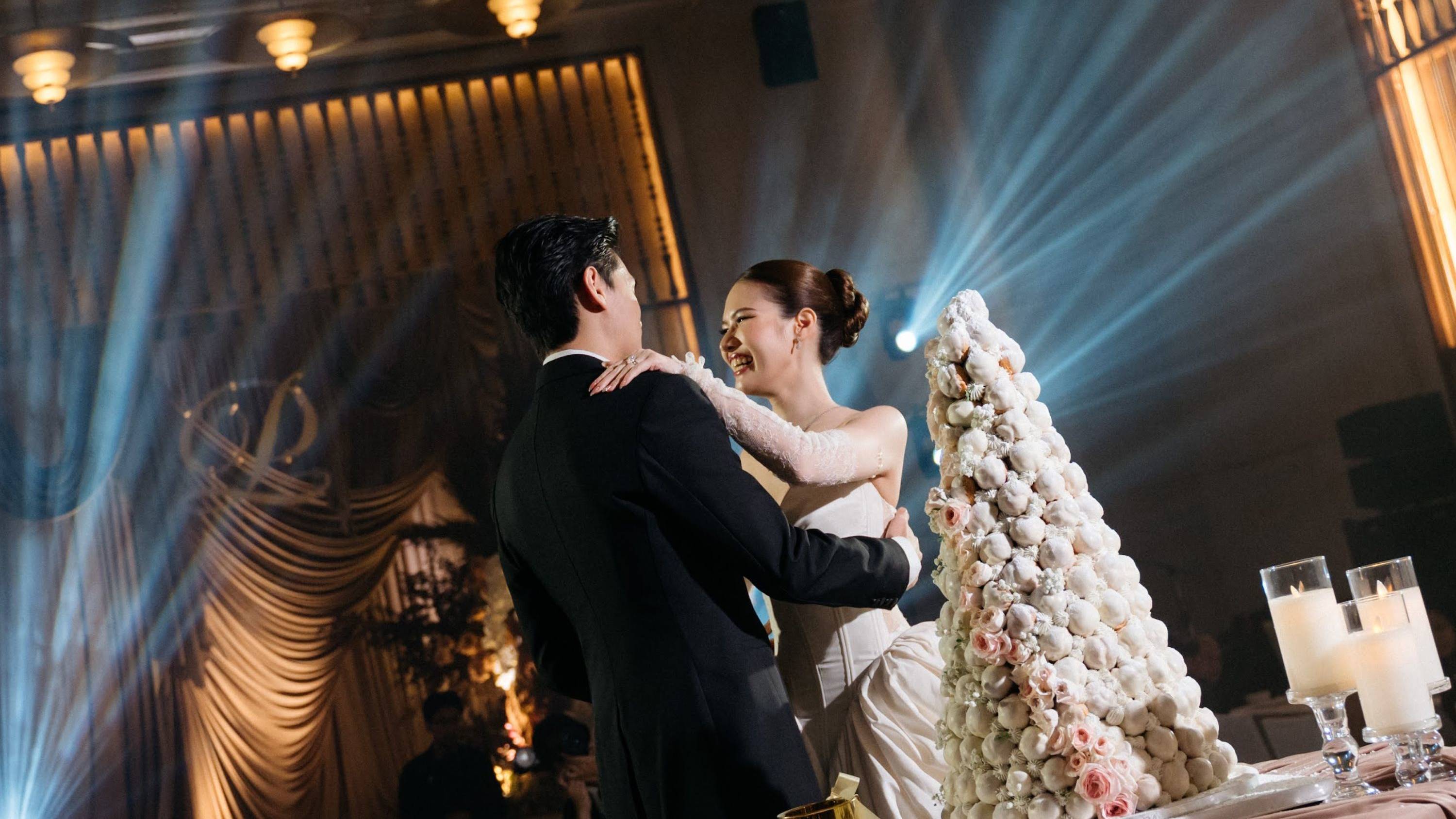 ステージから光が差し込むダンスフロアでダンスを楽しむ新郎新婦