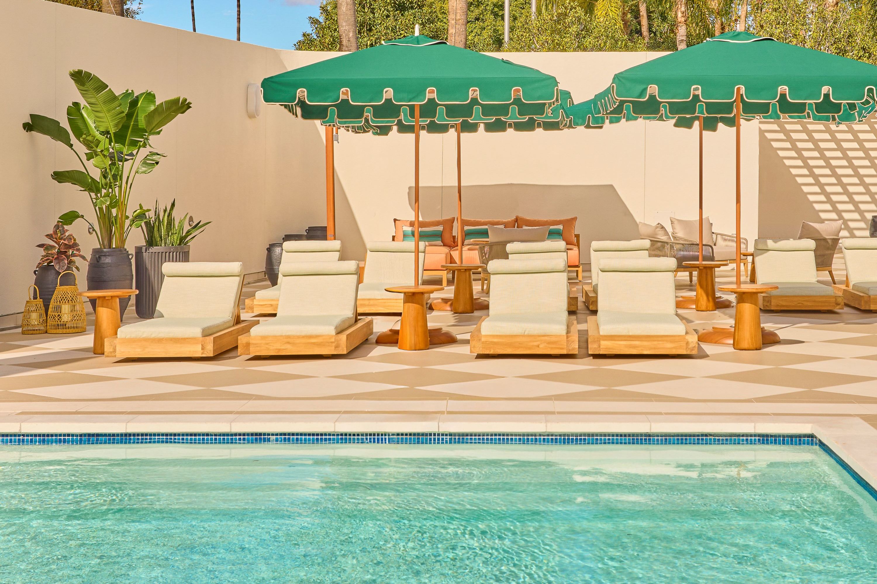 파라솔 아래 라운지 체어가 있는 야외 수영장 공간