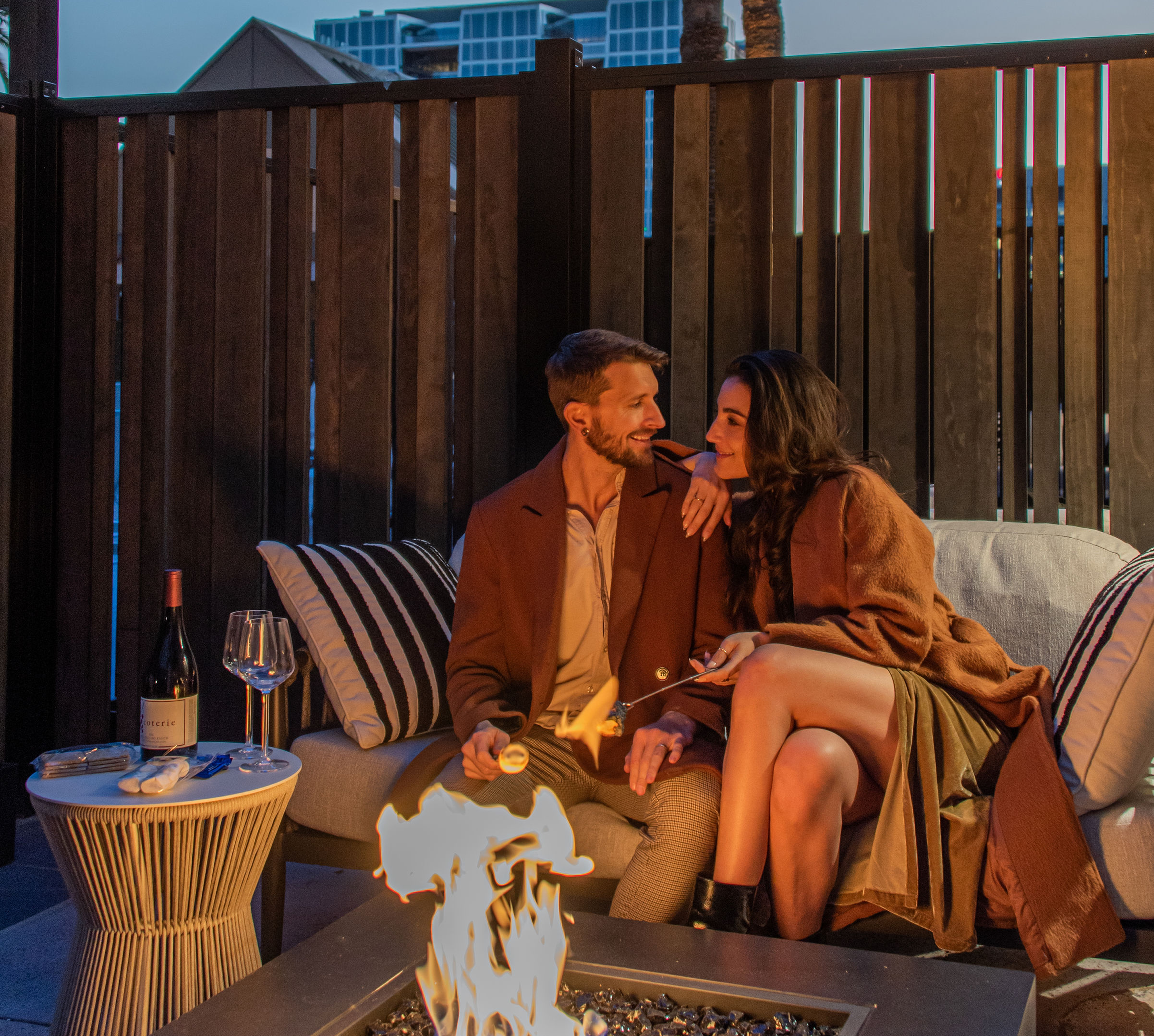 Couple Having Drinks by a Firepit in Poolside Patio