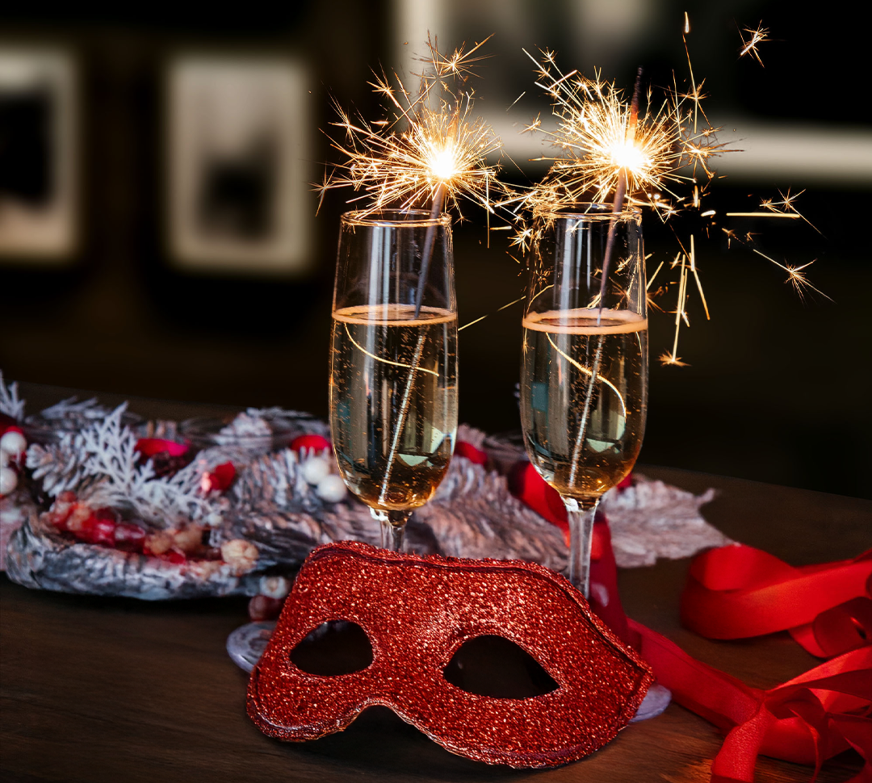 glasses of champagne with sparklers, red party mask