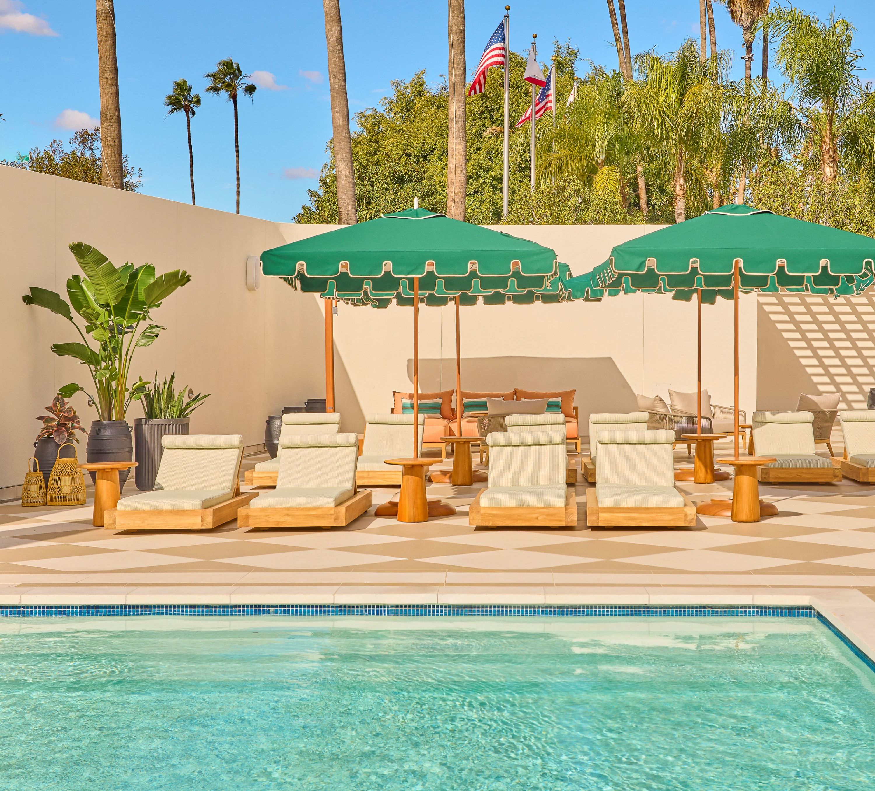 파라솔 아래 라운지 체어가 있는 야외 수영장 공간