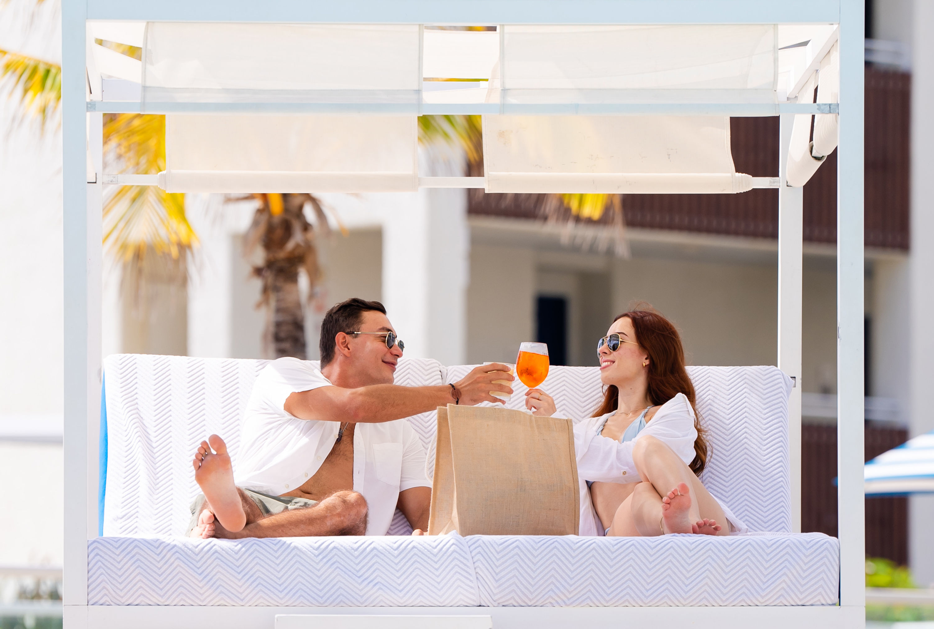 Couple relaxing and having drinks in outdoor pool area