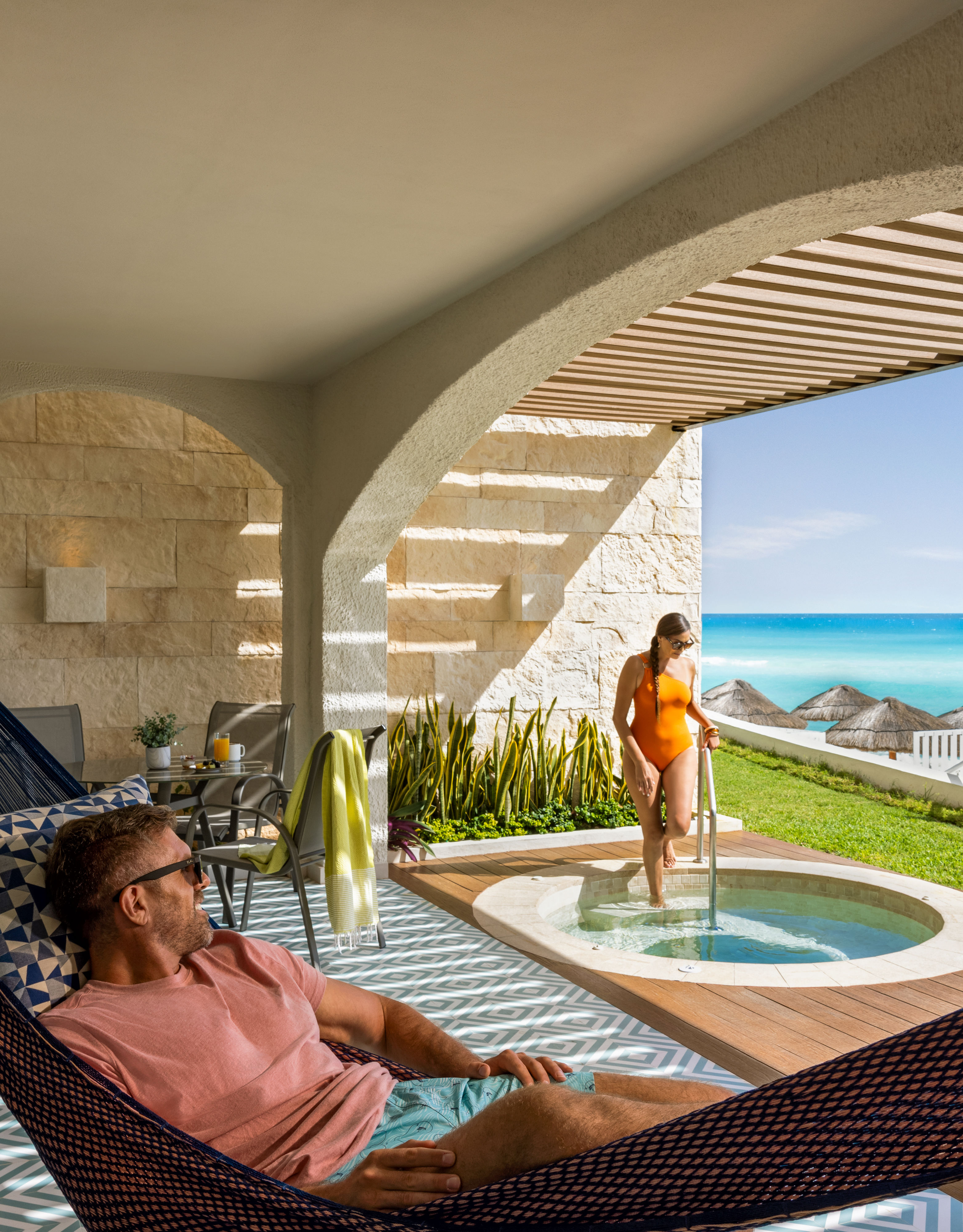 A suite patio with a hammock and hot tub.