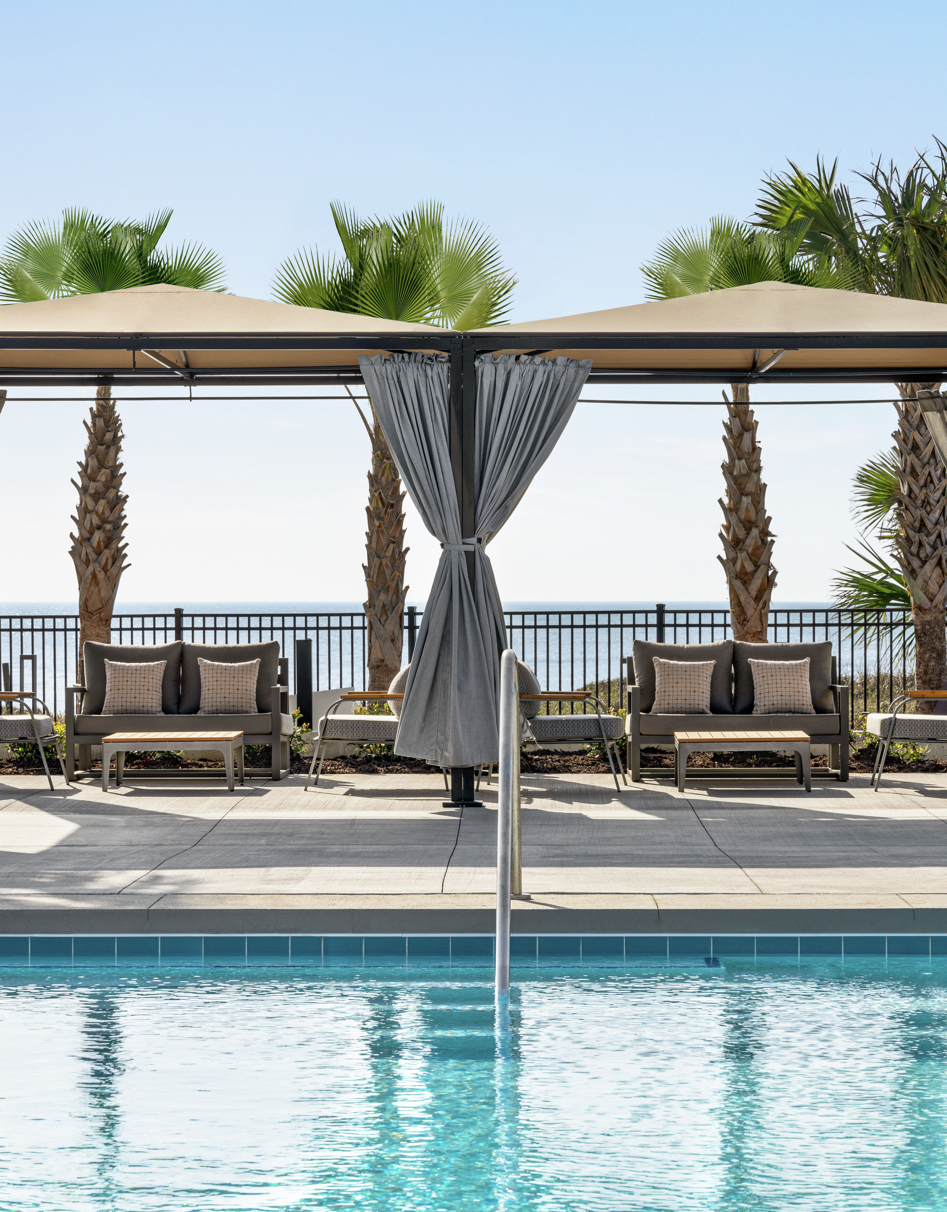Beautiful outdoor poolside cabanas with view of ocean