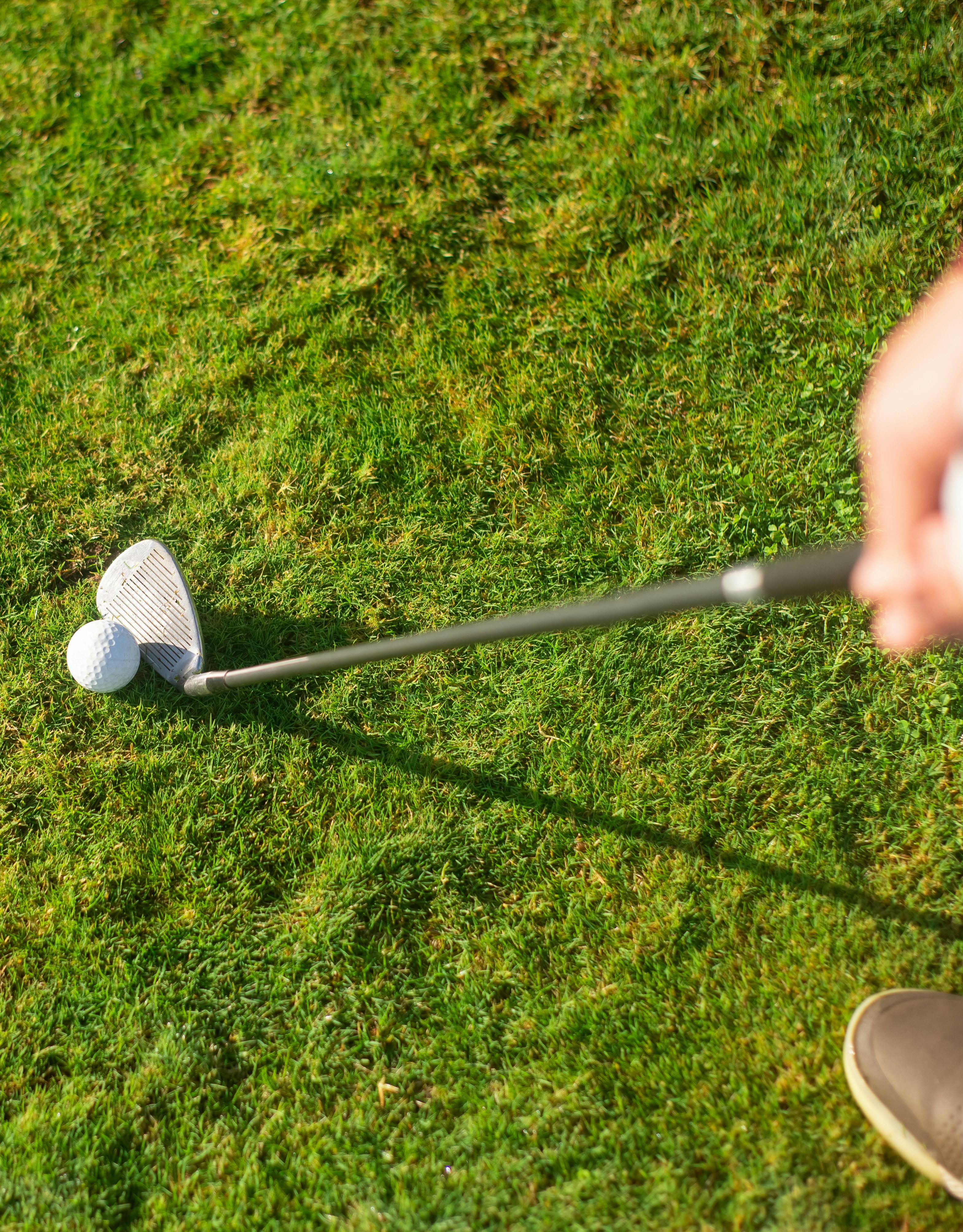 gambar stok orang yang memegang tongkat golf akan memukul bola golf