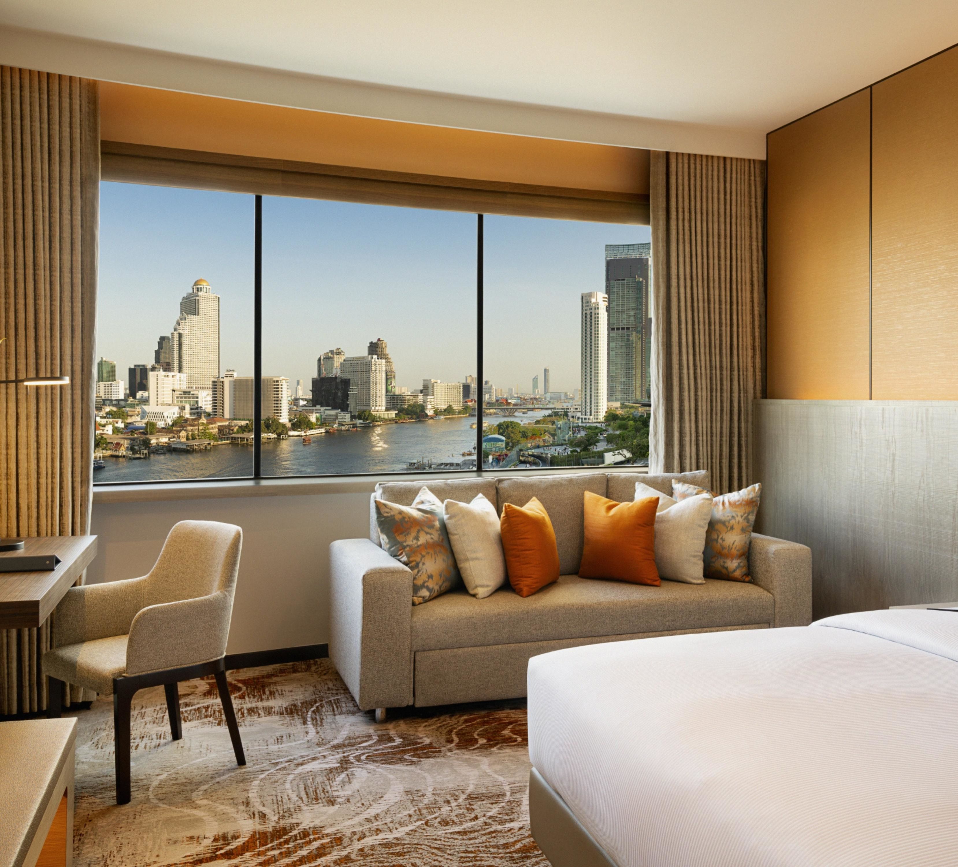 Chambre familiale avec grand lit, bureau, canapé et vue sur la ville