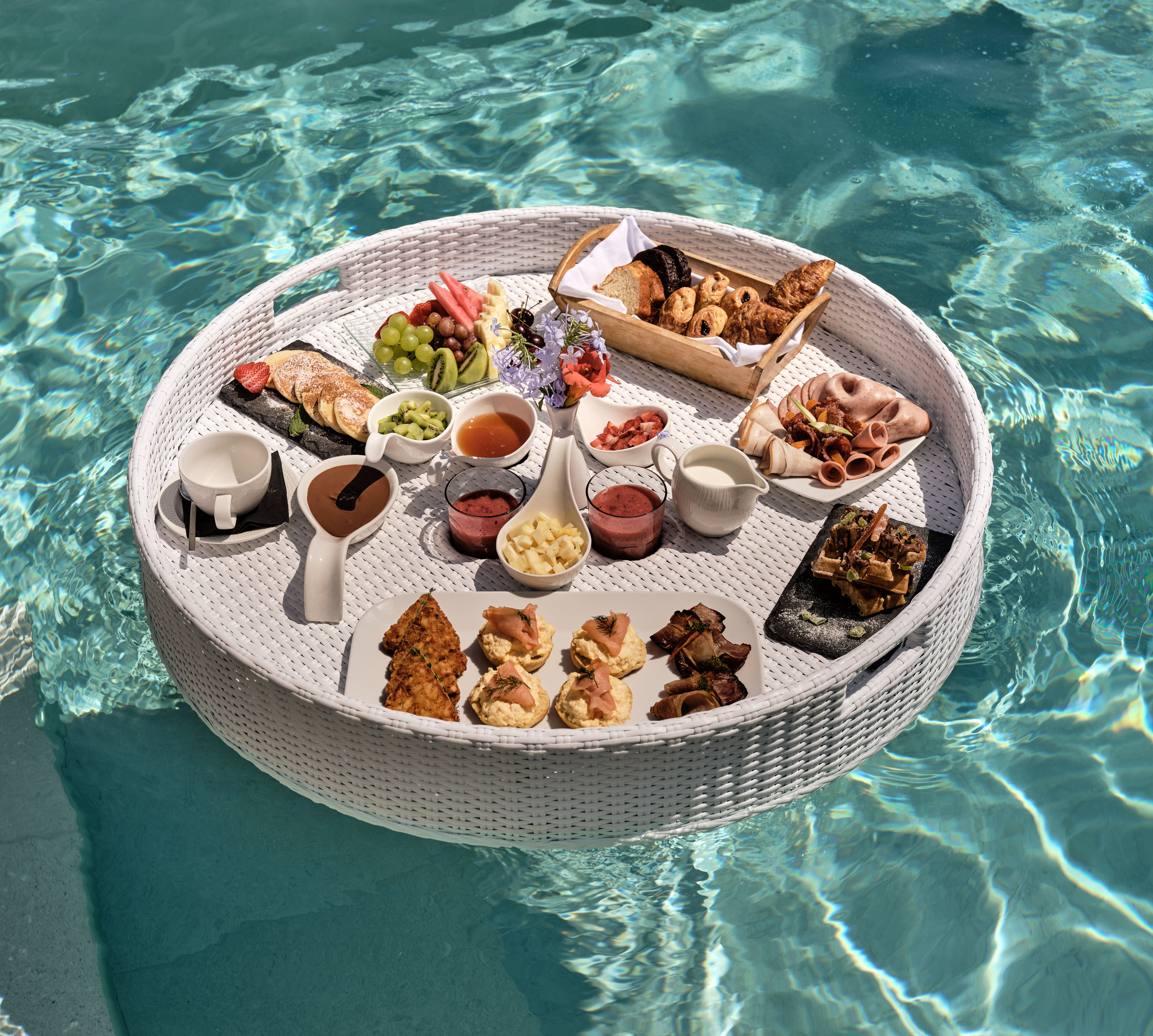 Panier flottant sur l'eau avec sélection de plats pour le petit déjeuner