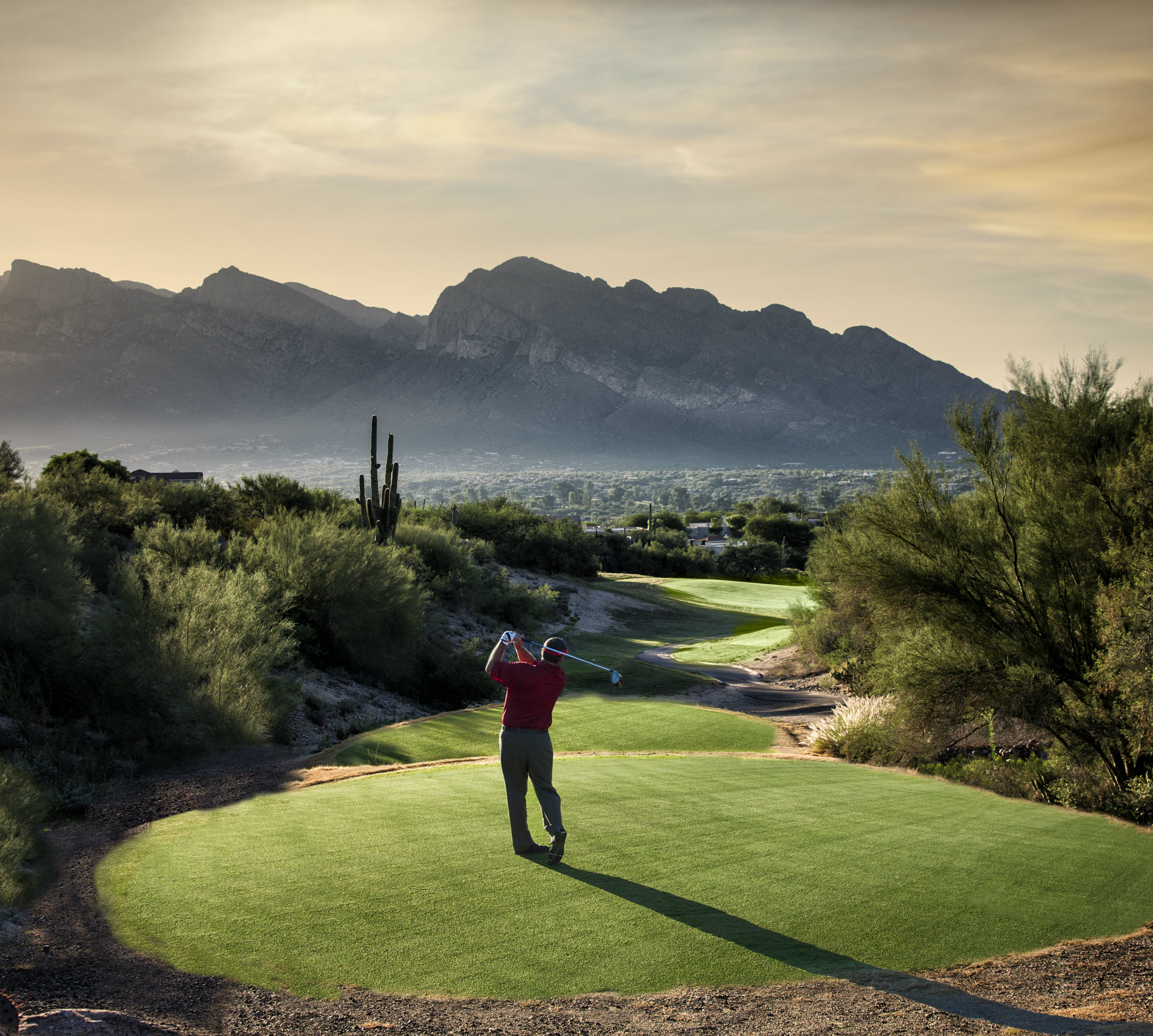 Golfer on course at sunset