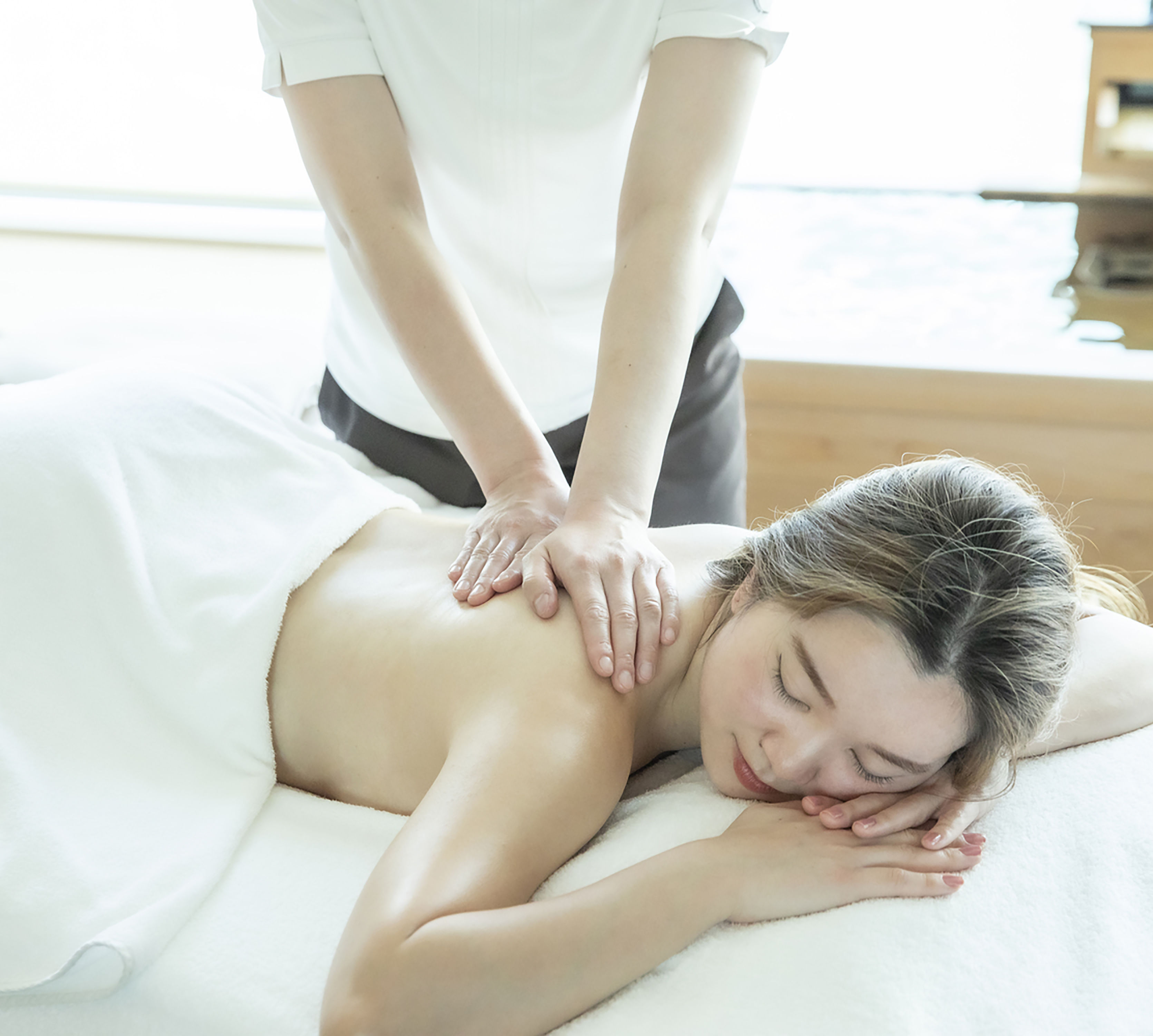 Woman laying on table getting a massage at the spa
