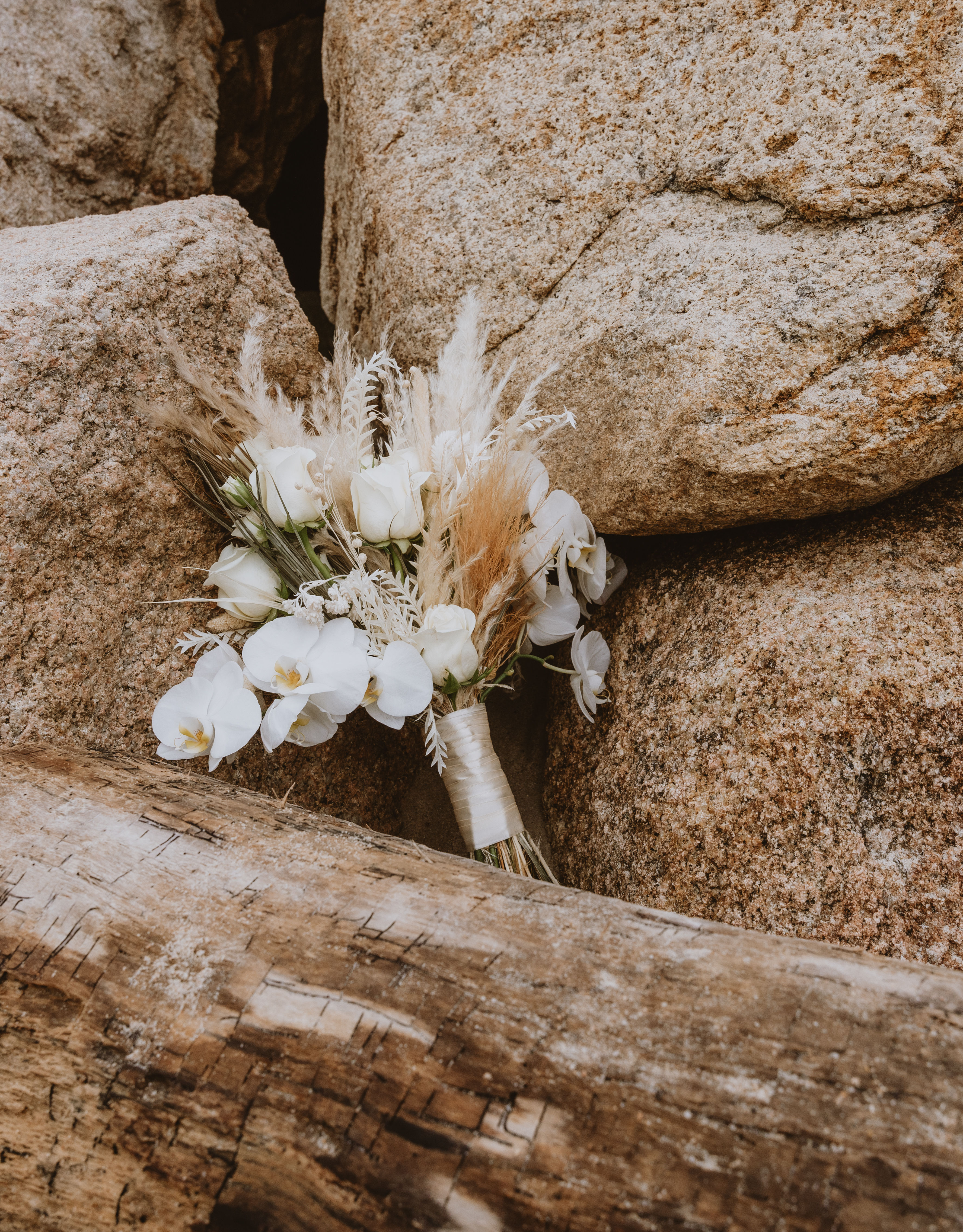 Ramo de novia apoyado sobre rocas en la playa