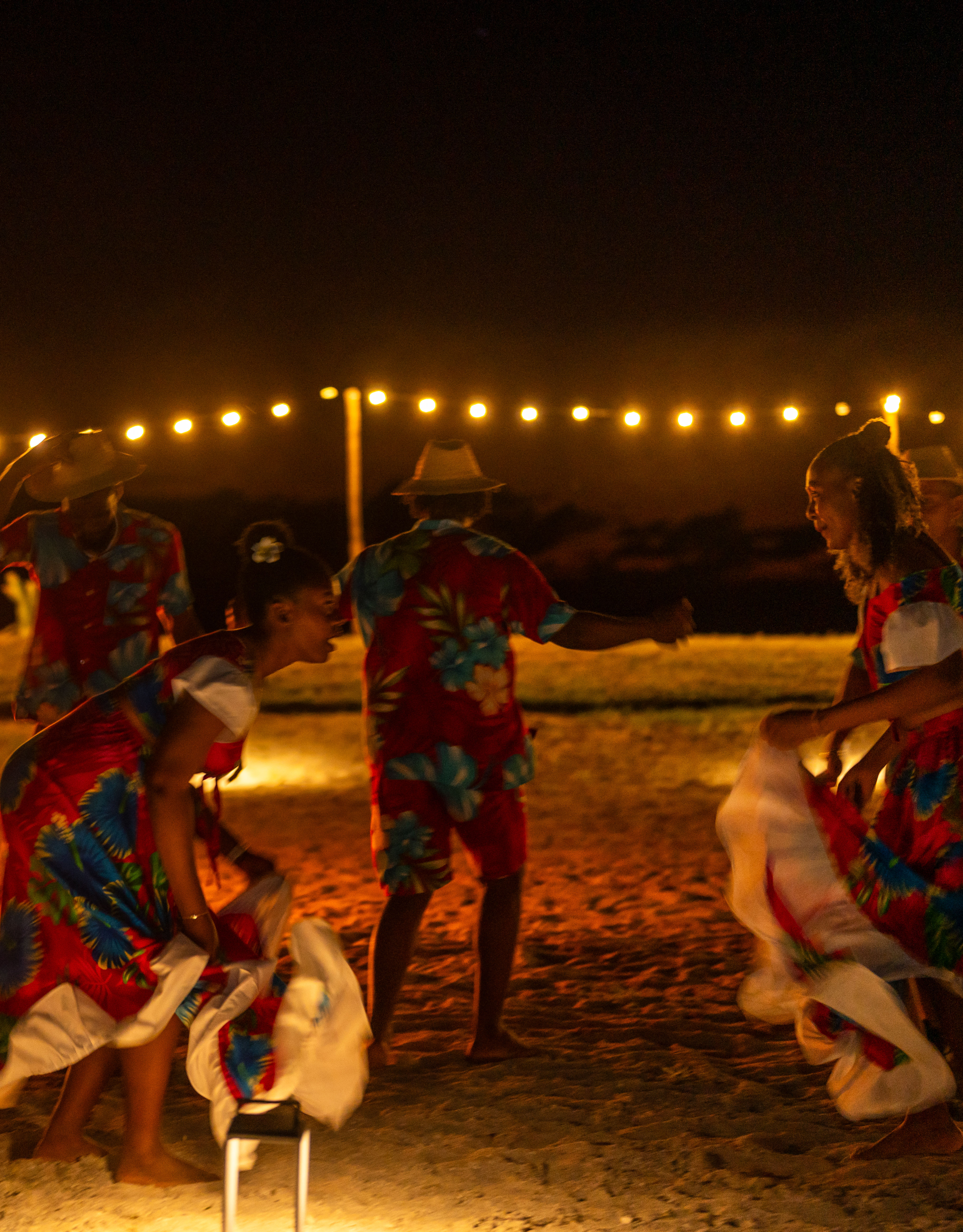 Oameni care dansează lângă o foarfecă și se distrează pe plajă