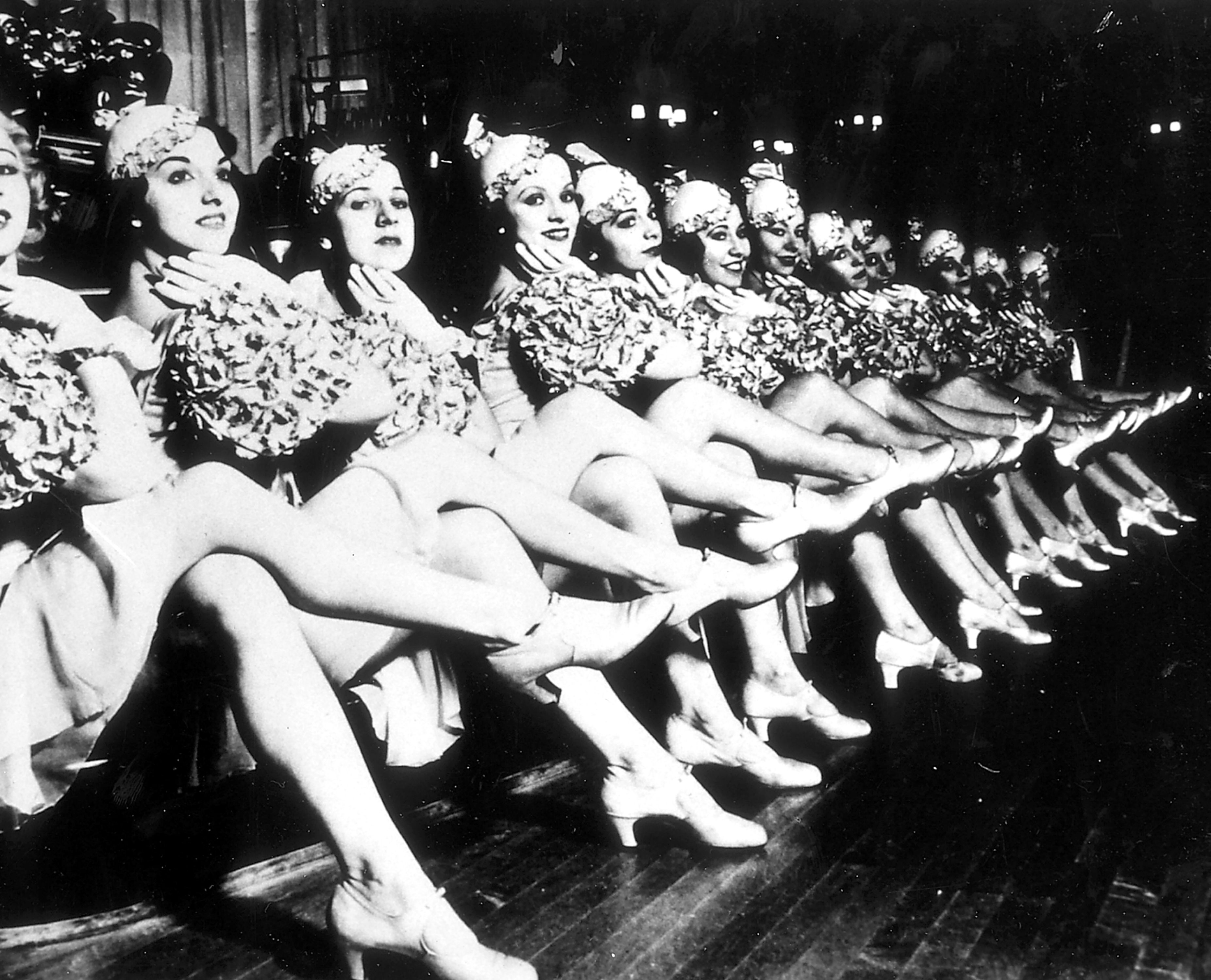 black and white image of women with legs crossed