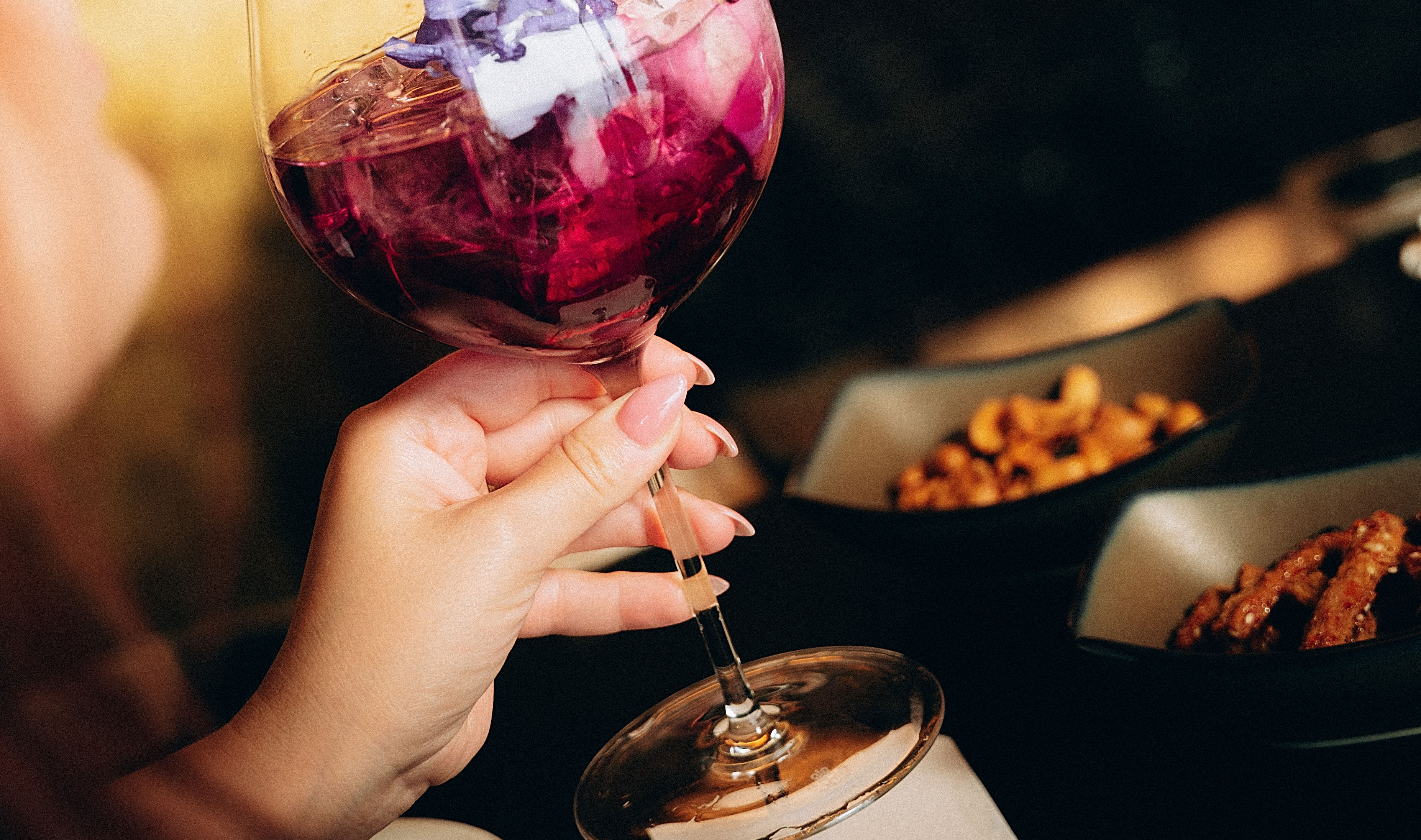 O femeie având un cocktail la KO Lounge