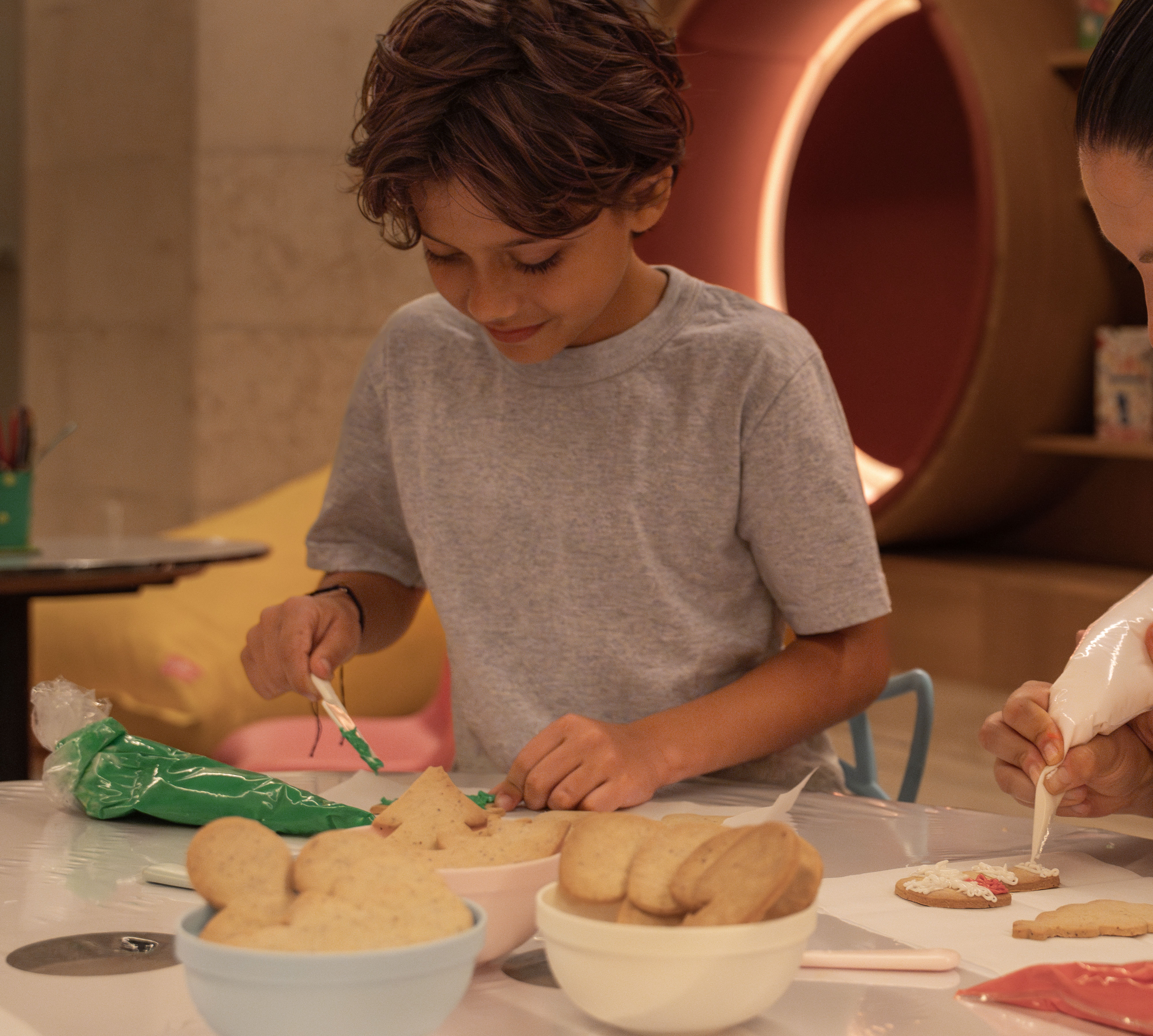 Ein Junge und eine Frau bei unterhaltsamen Aktivitäten im Kids Club