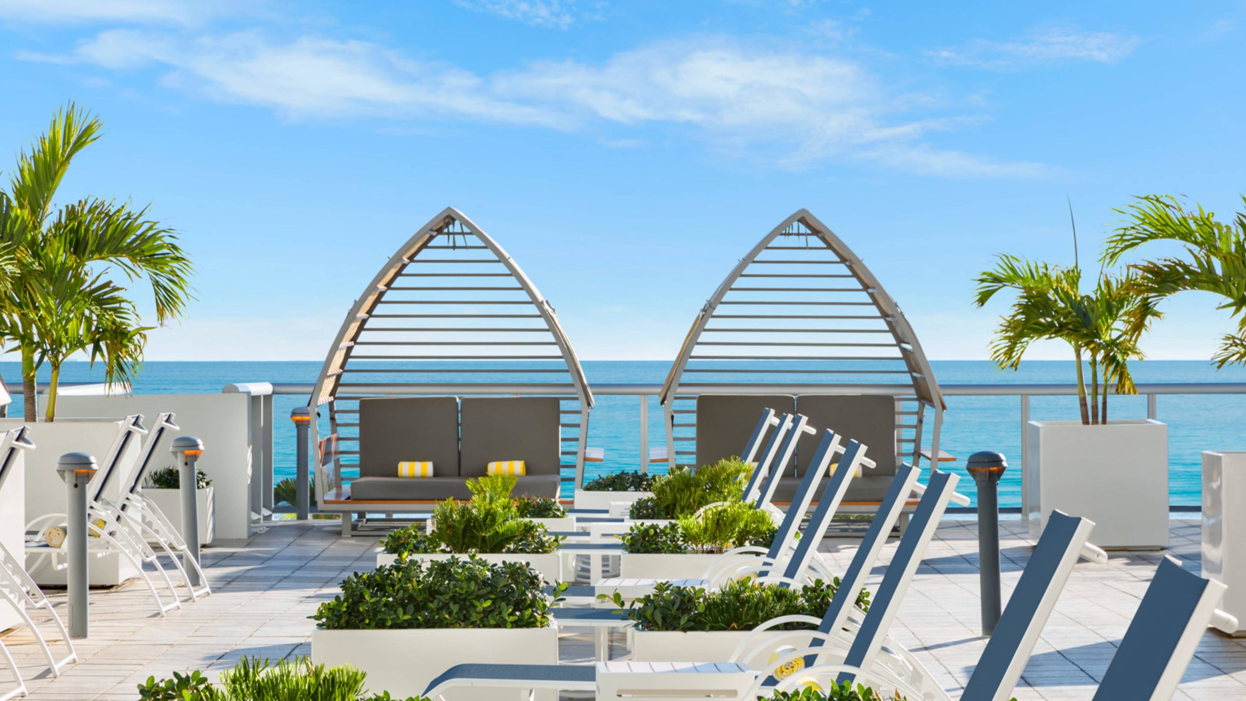 Lounge chairs and cabanas with view of ocean