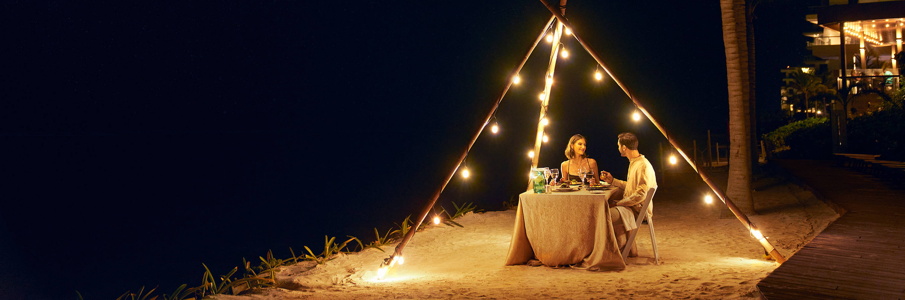 couple sitting at table on beach