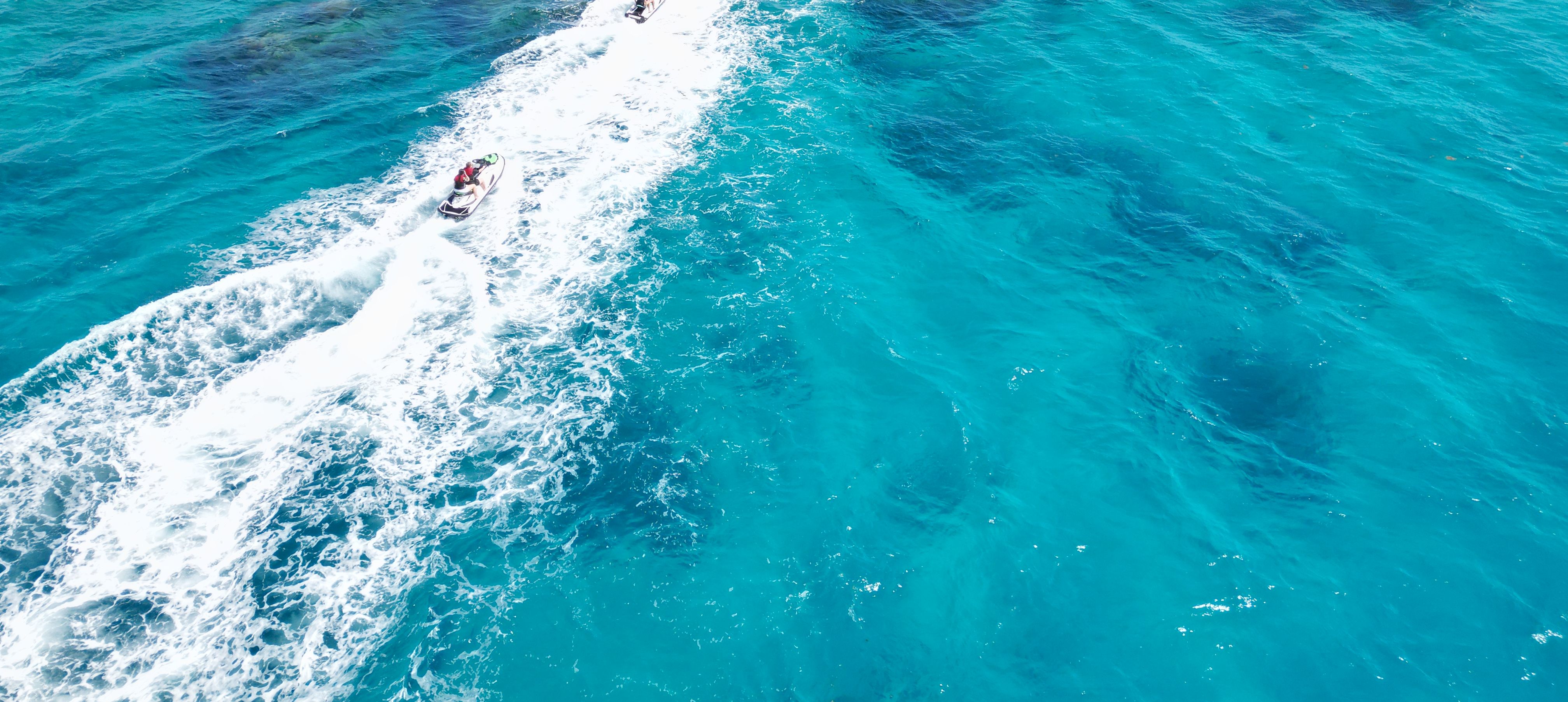 Jetskiers in clear blue water