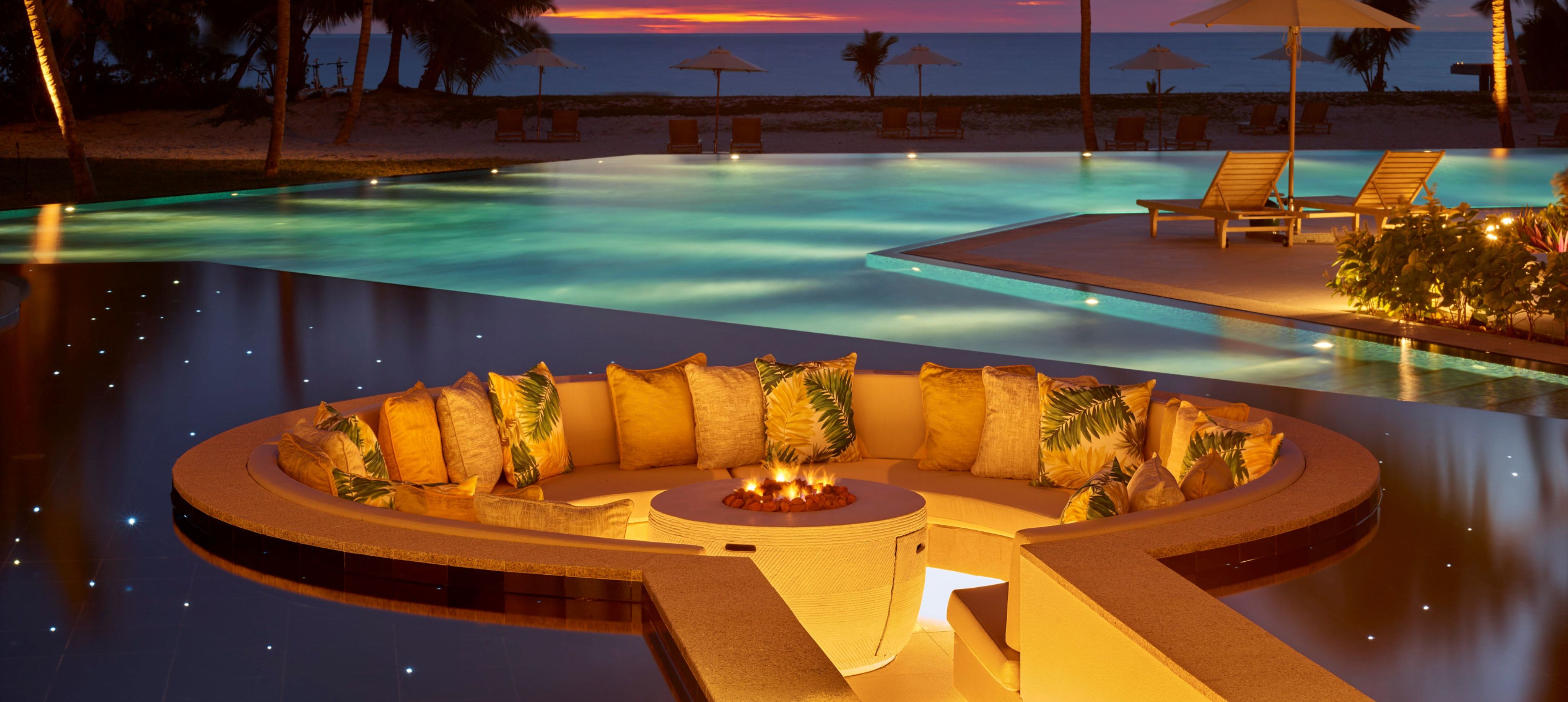 night time shot of pool with ocean in background