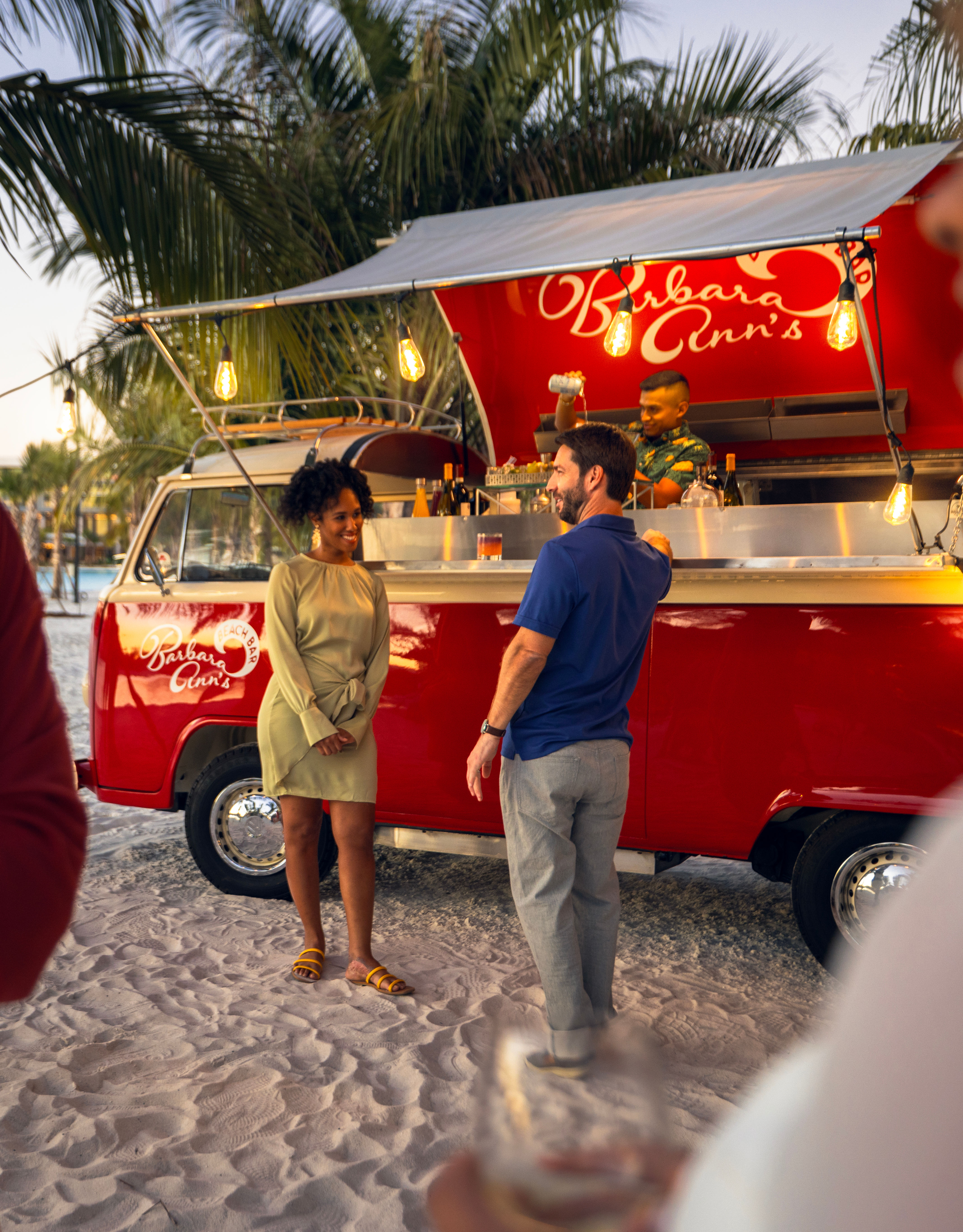 Frau lächelt, während sie mit Wein in der Hand plaudert