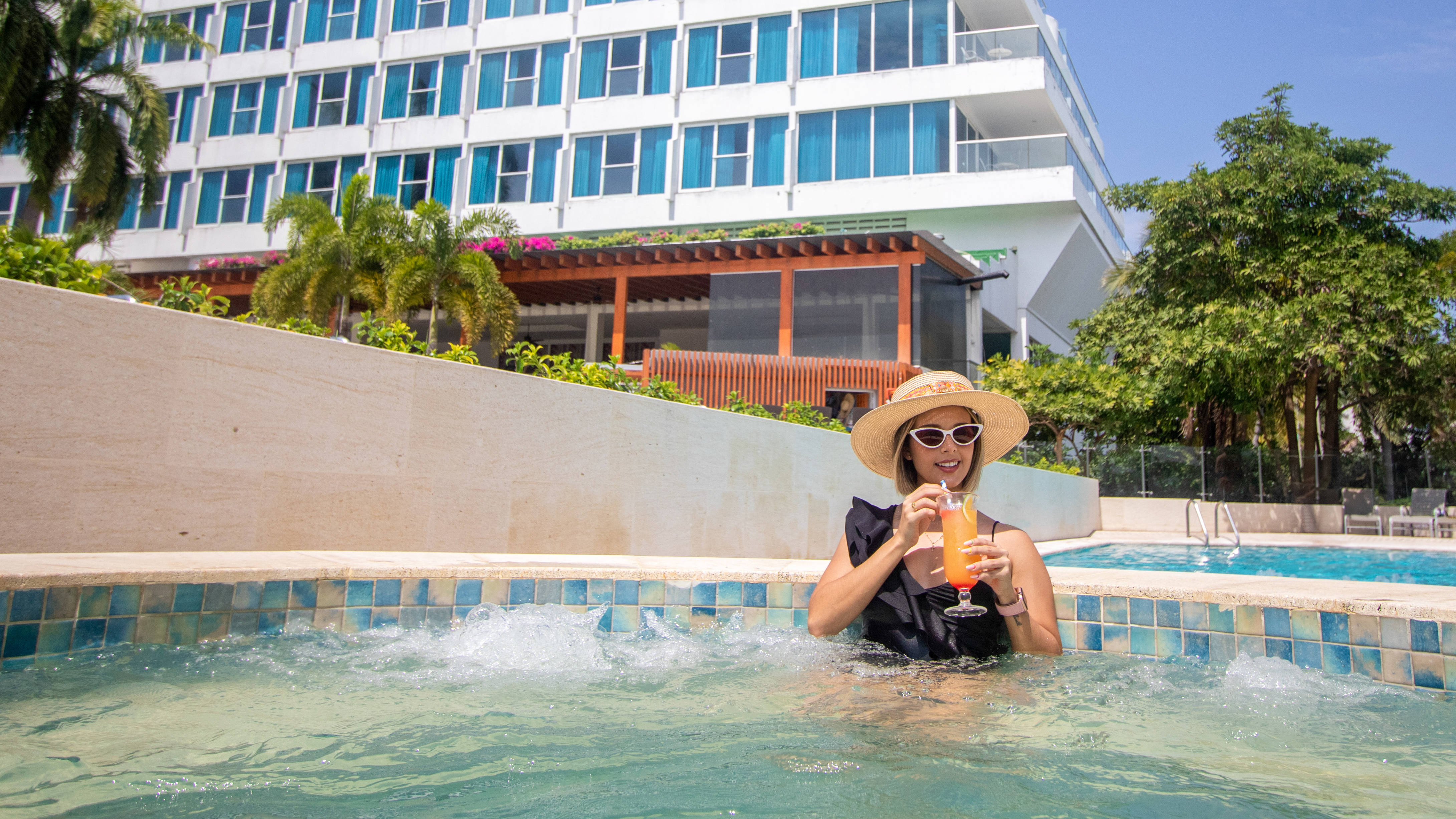 Woman drinking a cocktail in the pool