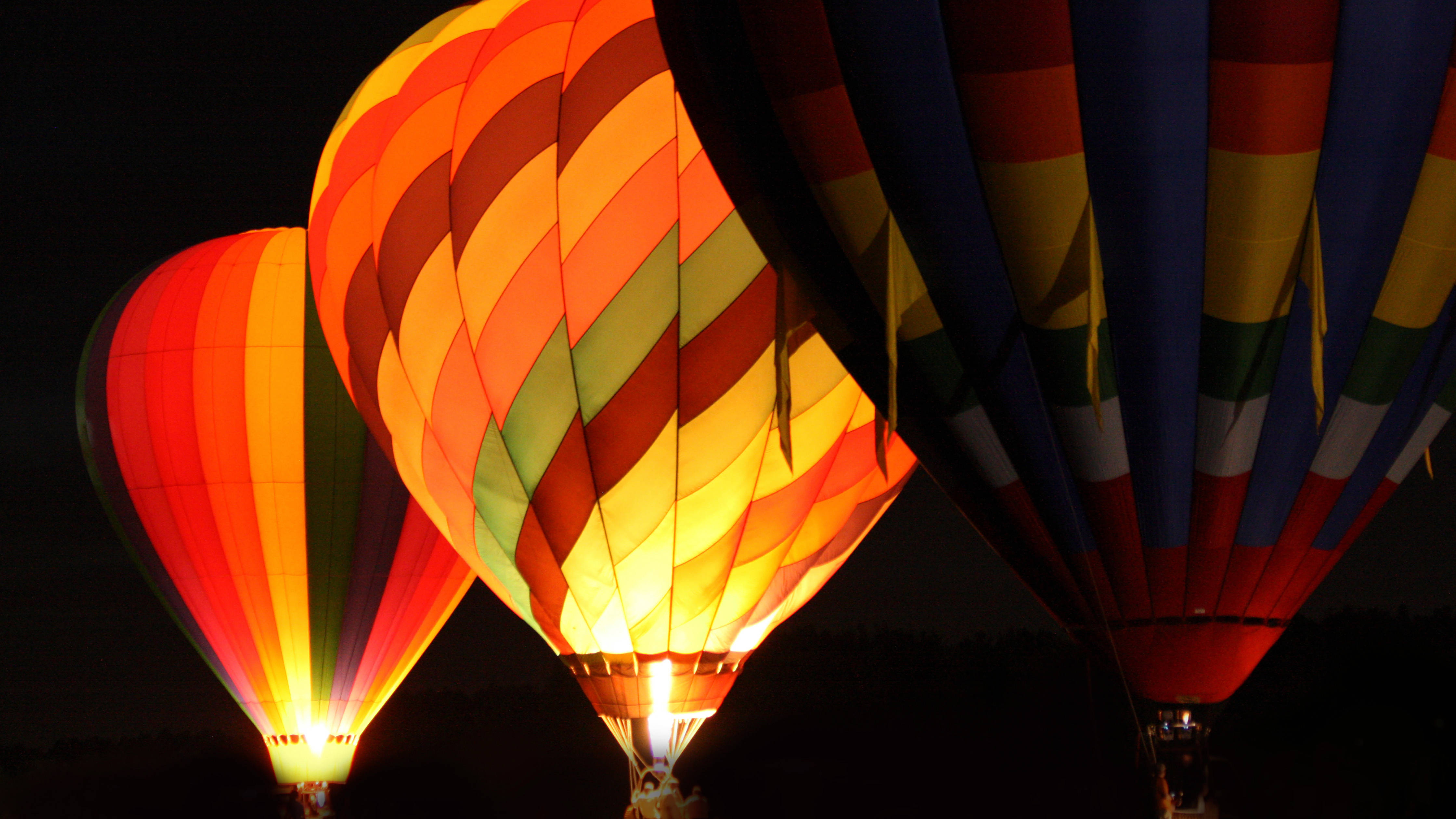 Variety of colourful hot air balloons at night