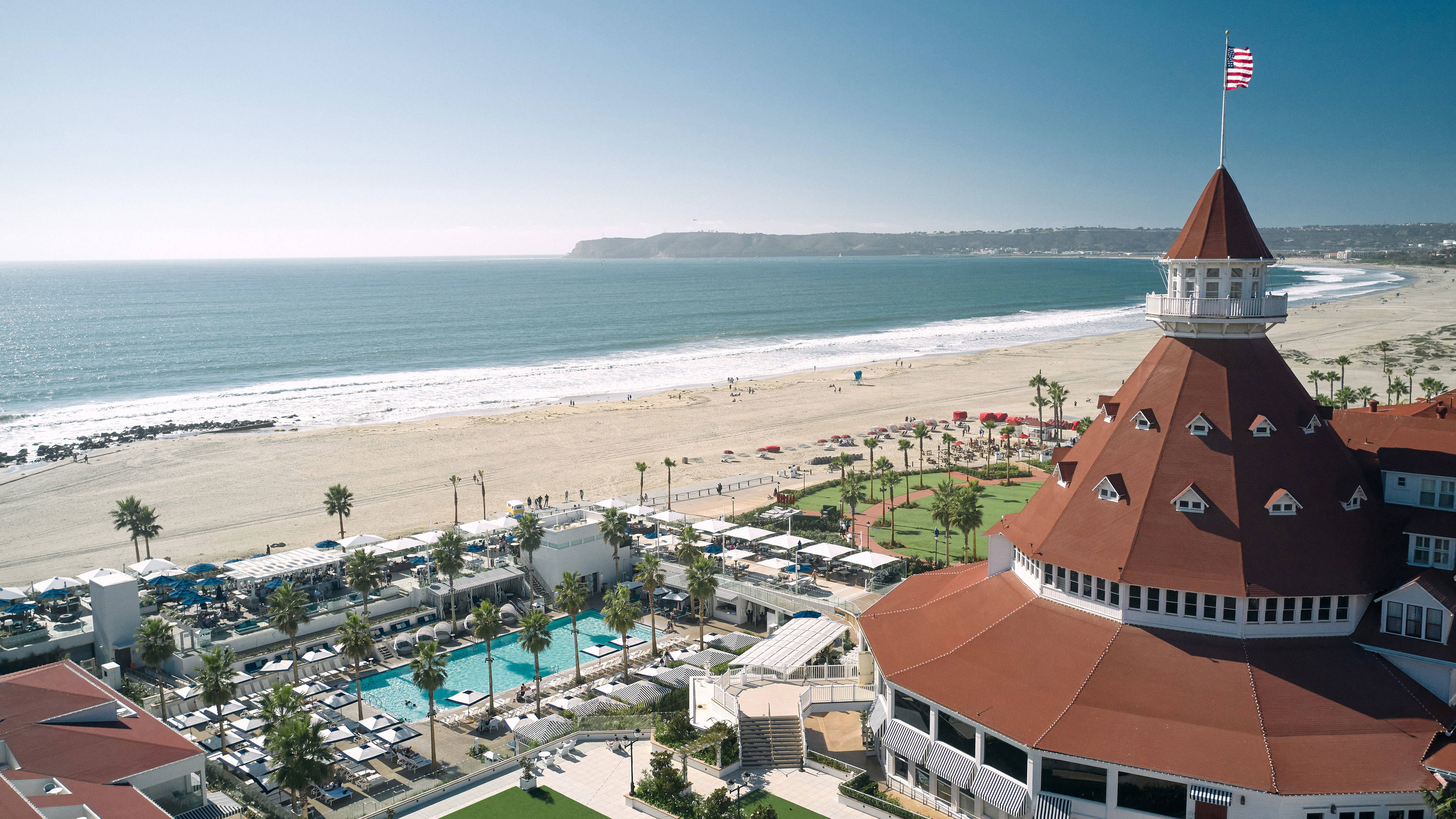 Fachada del hotel con área de piscina junto a la playa