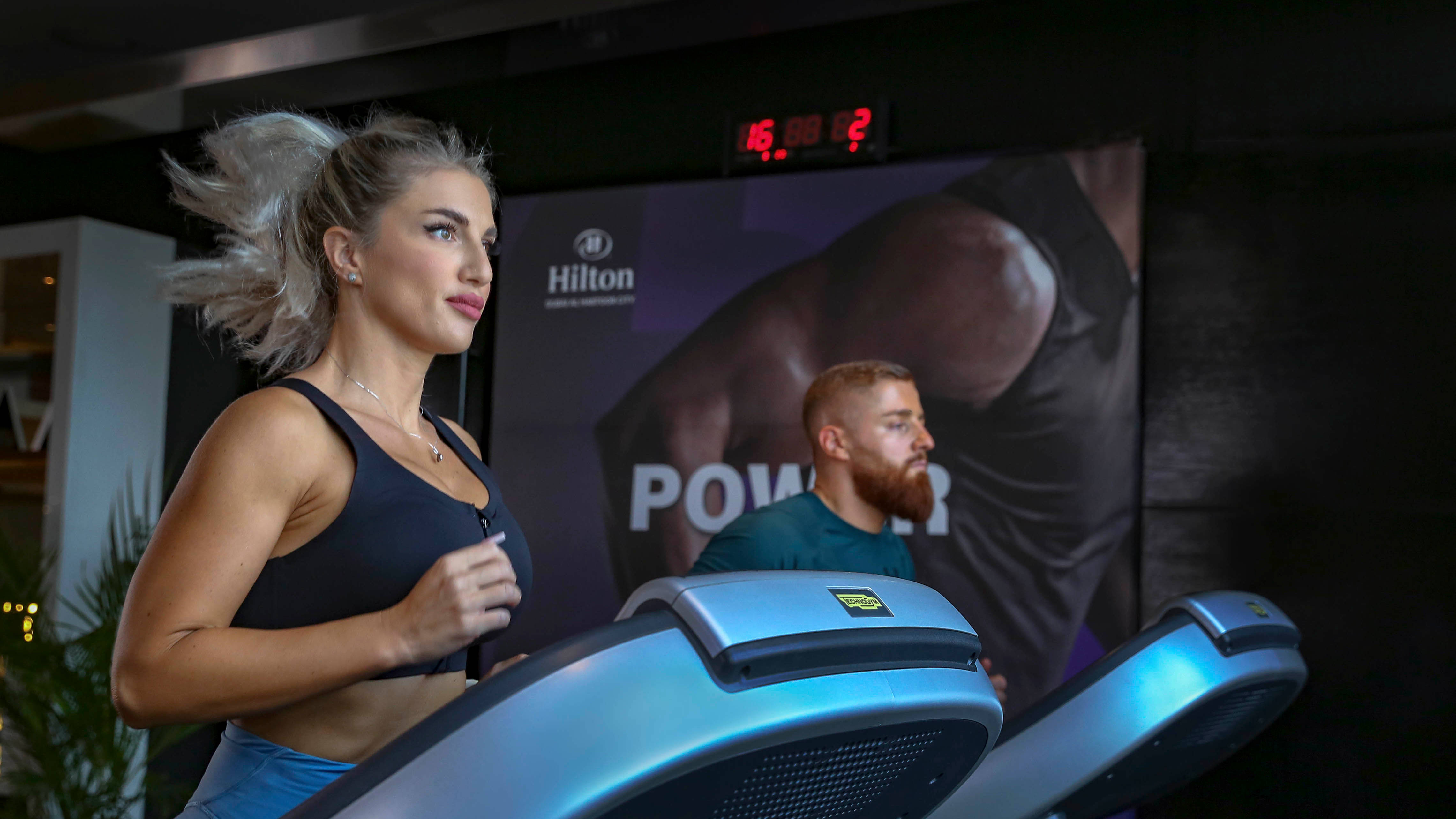 man and woman running on treadmills in the fitness center