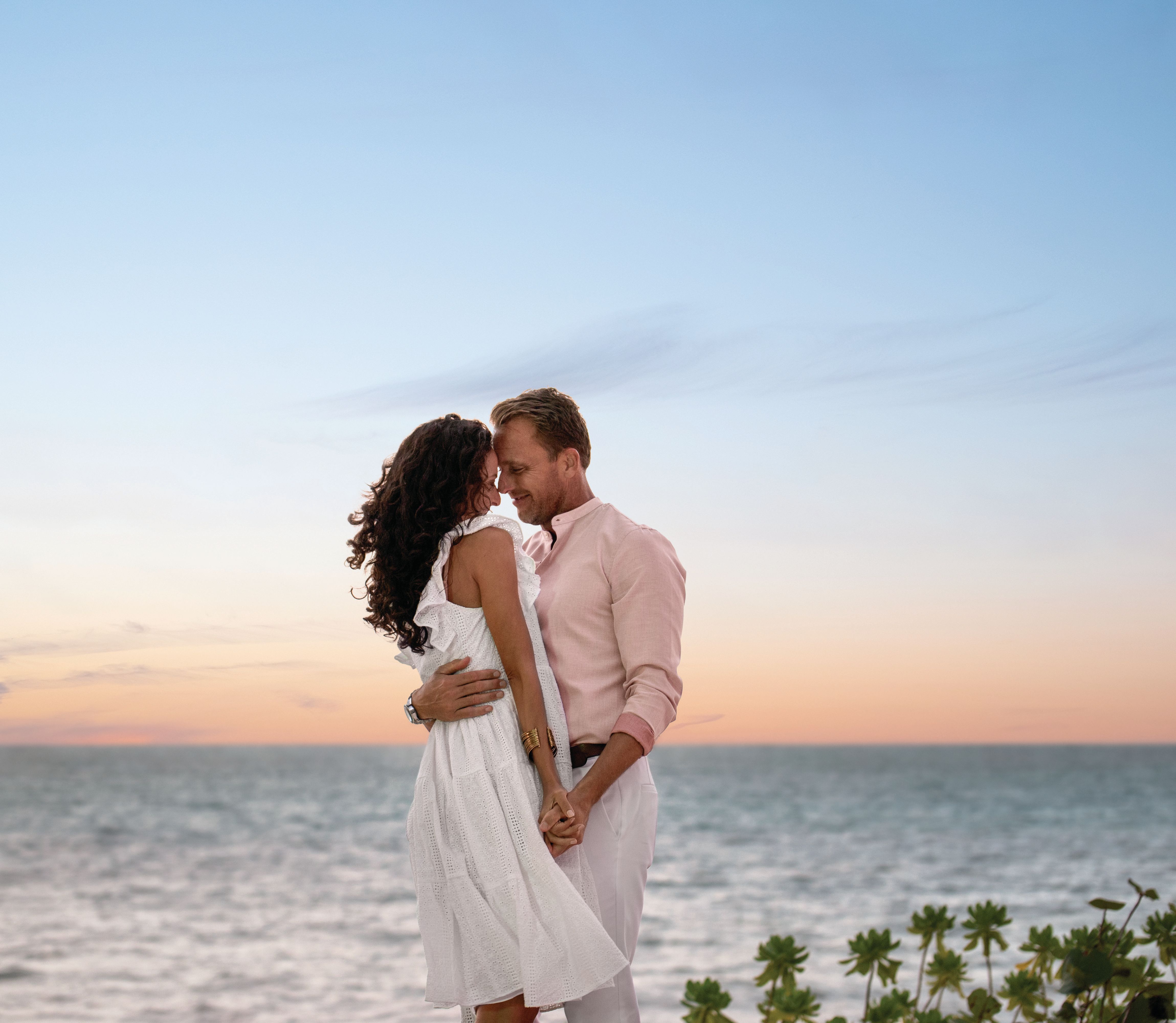 Couple embraces in front of the ocean