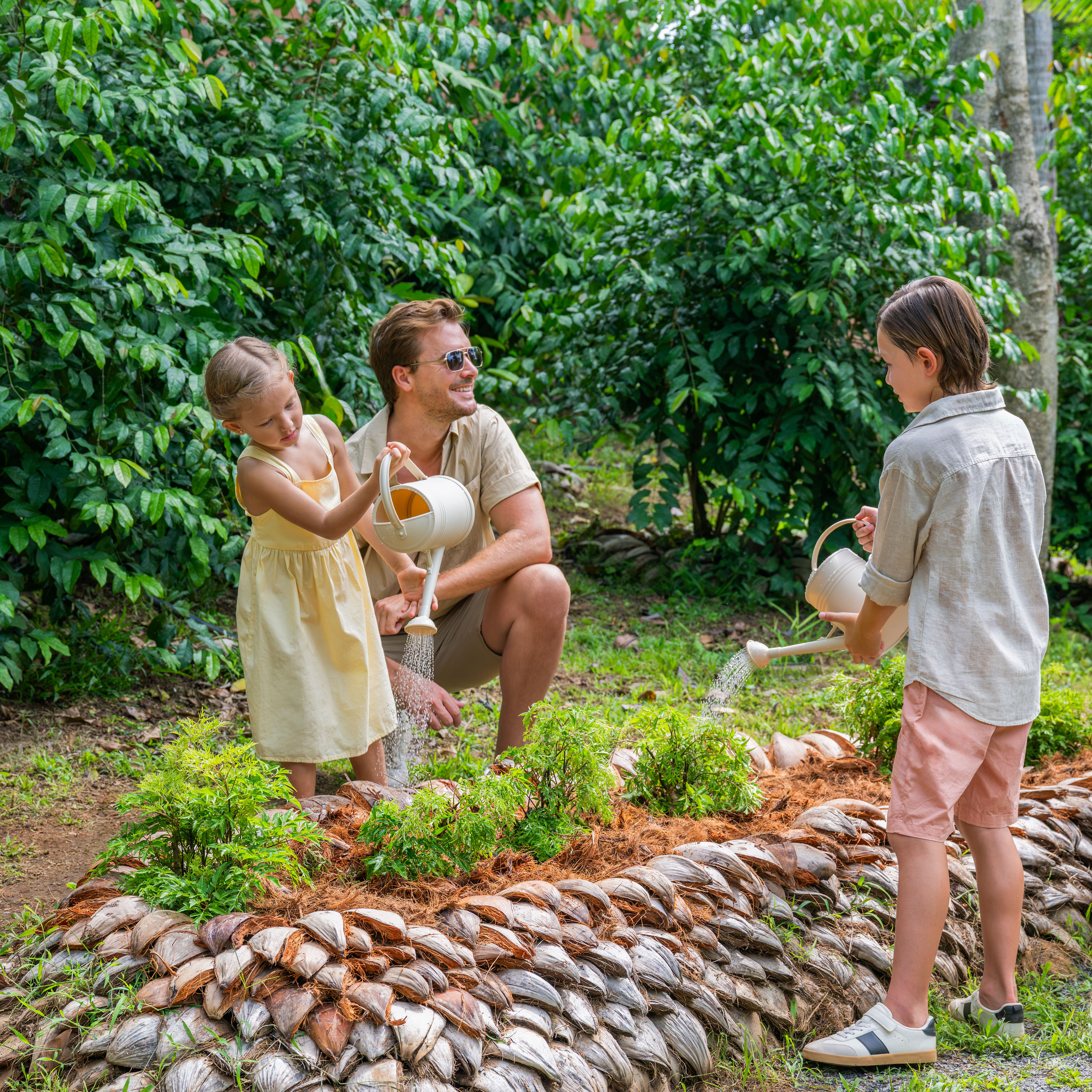 Família regando um jardim na Iris Farm