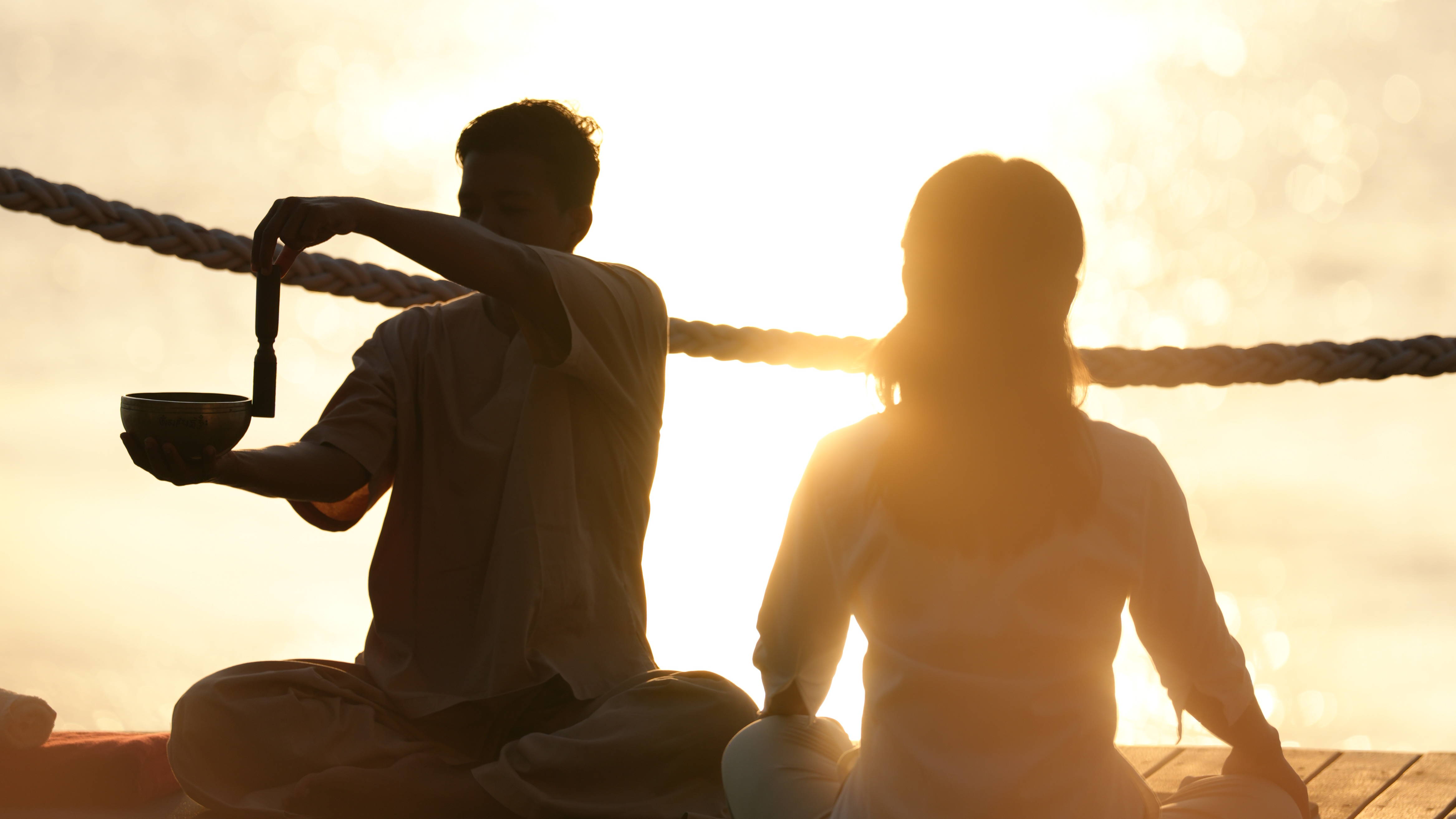 Persone che praticano la meditazione al tramonto