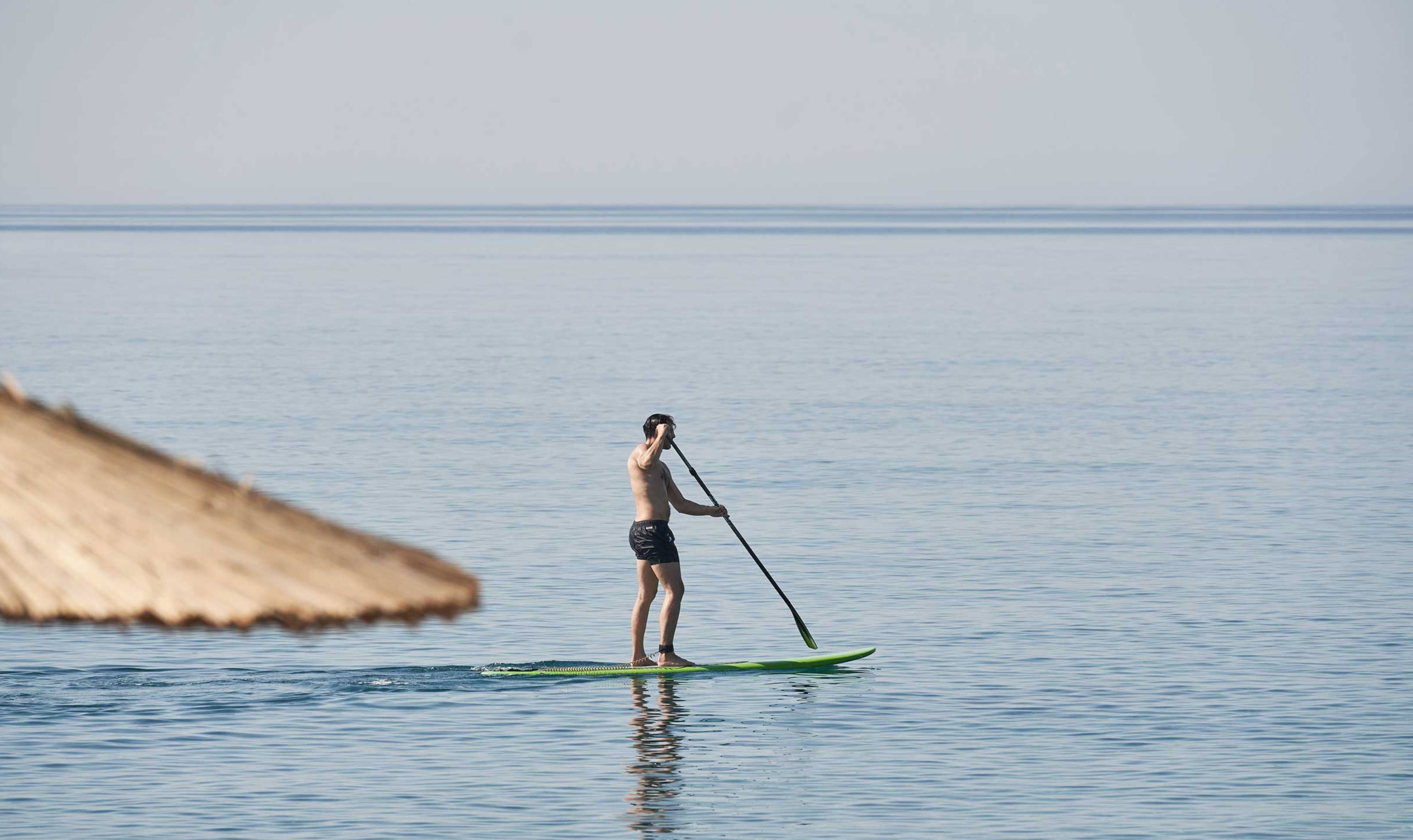Homem paddle boarding no mar