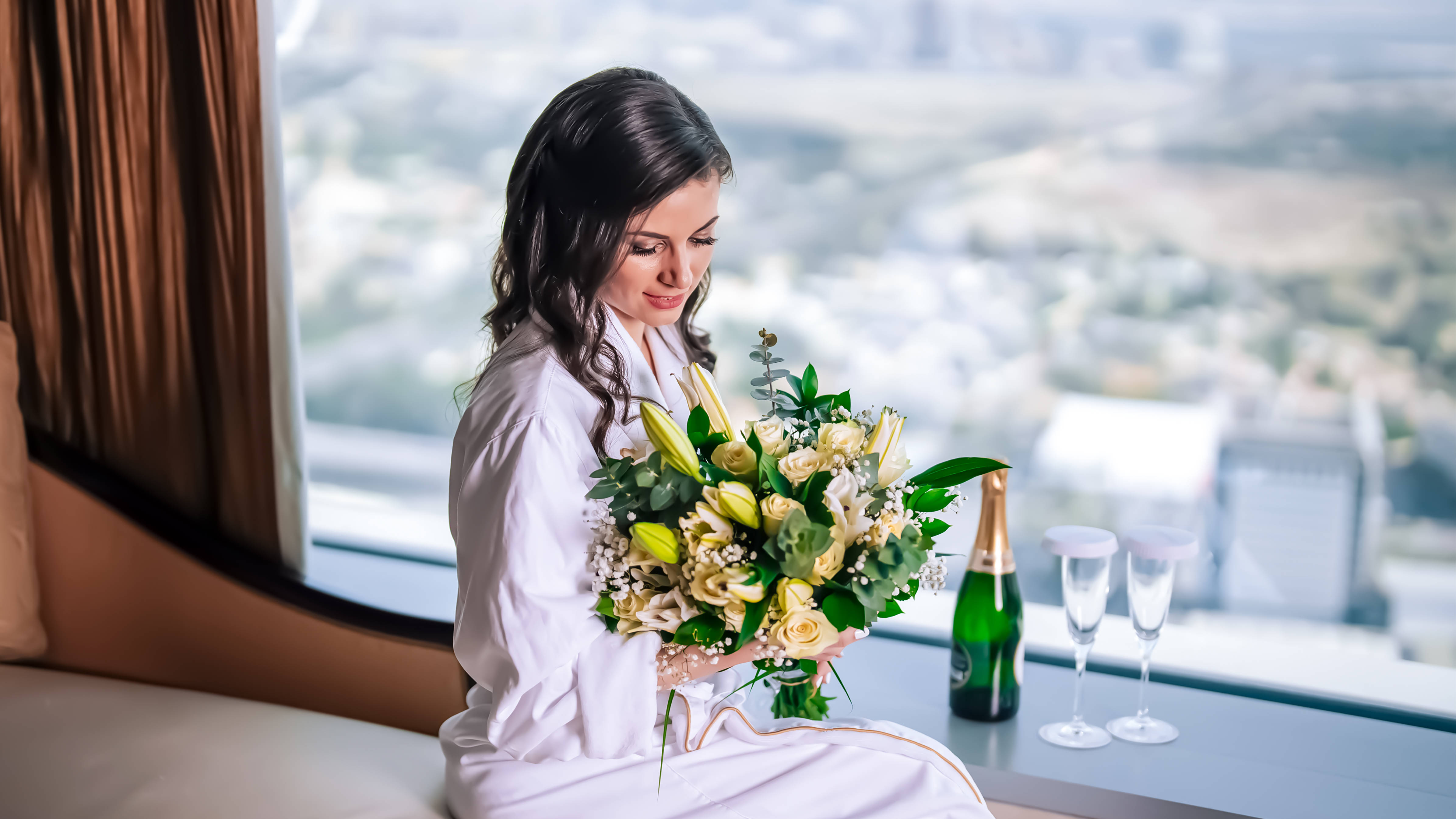 bride sitting looking down at her bouquet