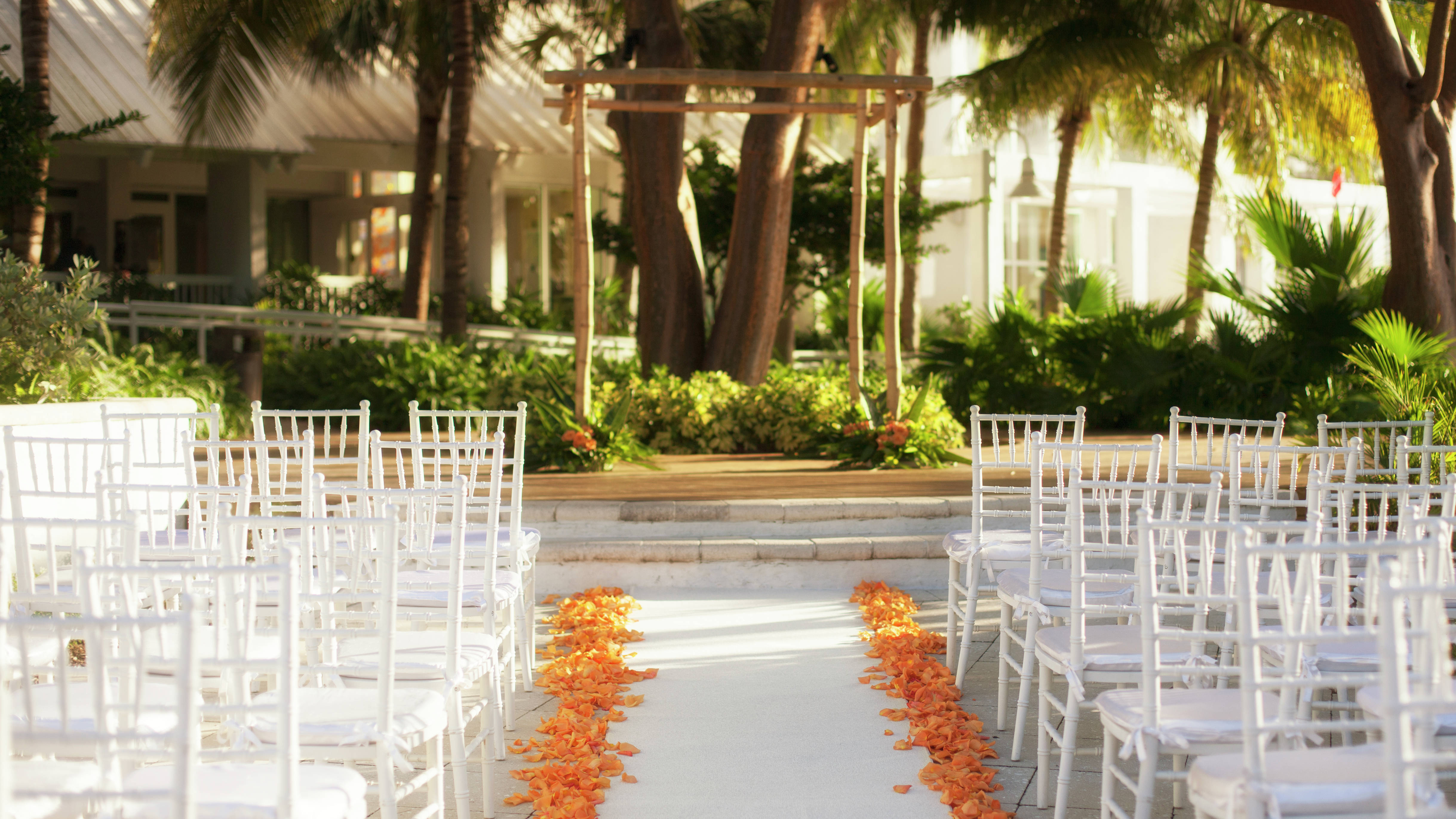 Orange Petals Along Aisle of Chairs Facing Outdoor Wedding Ceremony Space