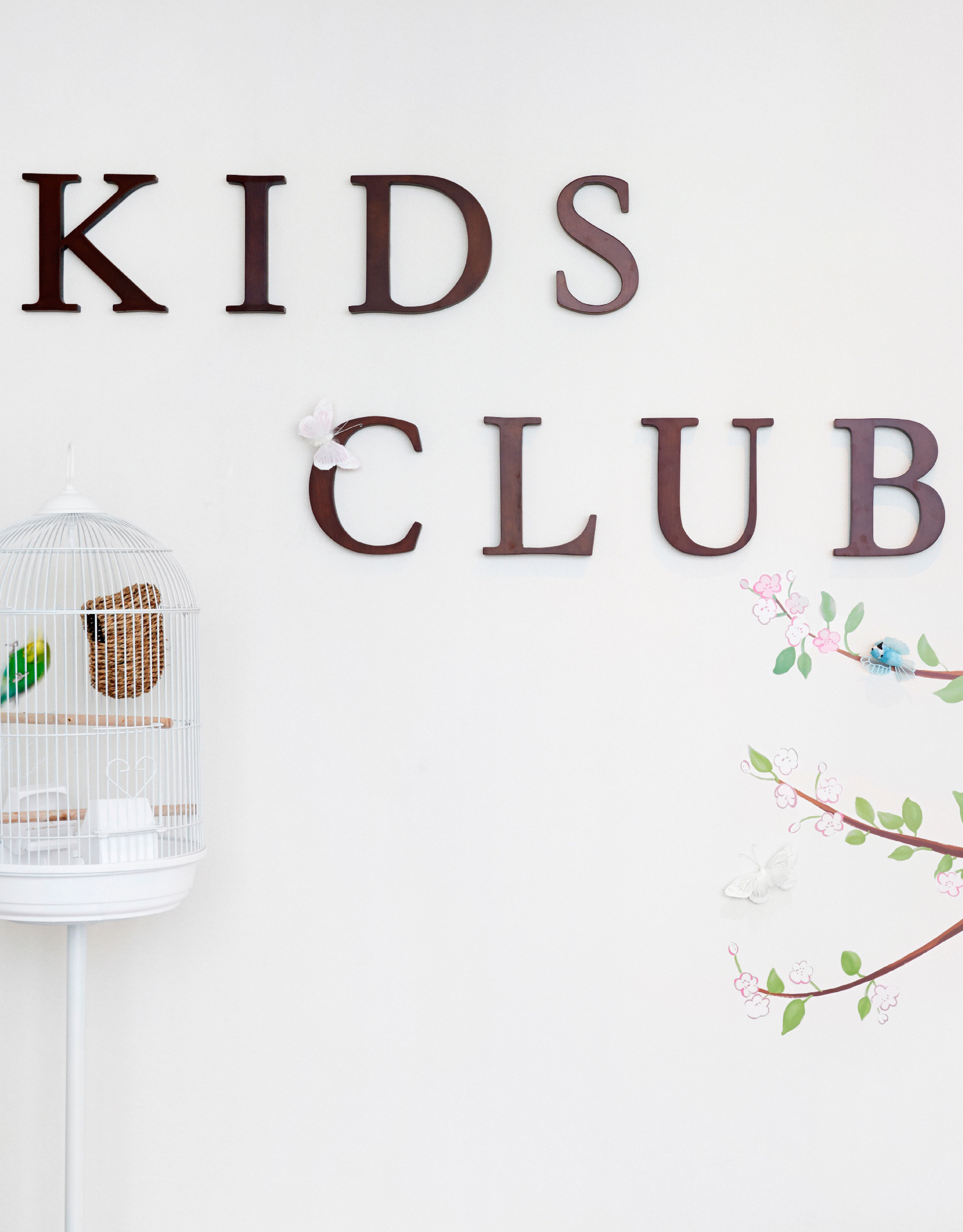 Cartello del Kids Club con gabbia per uccelli