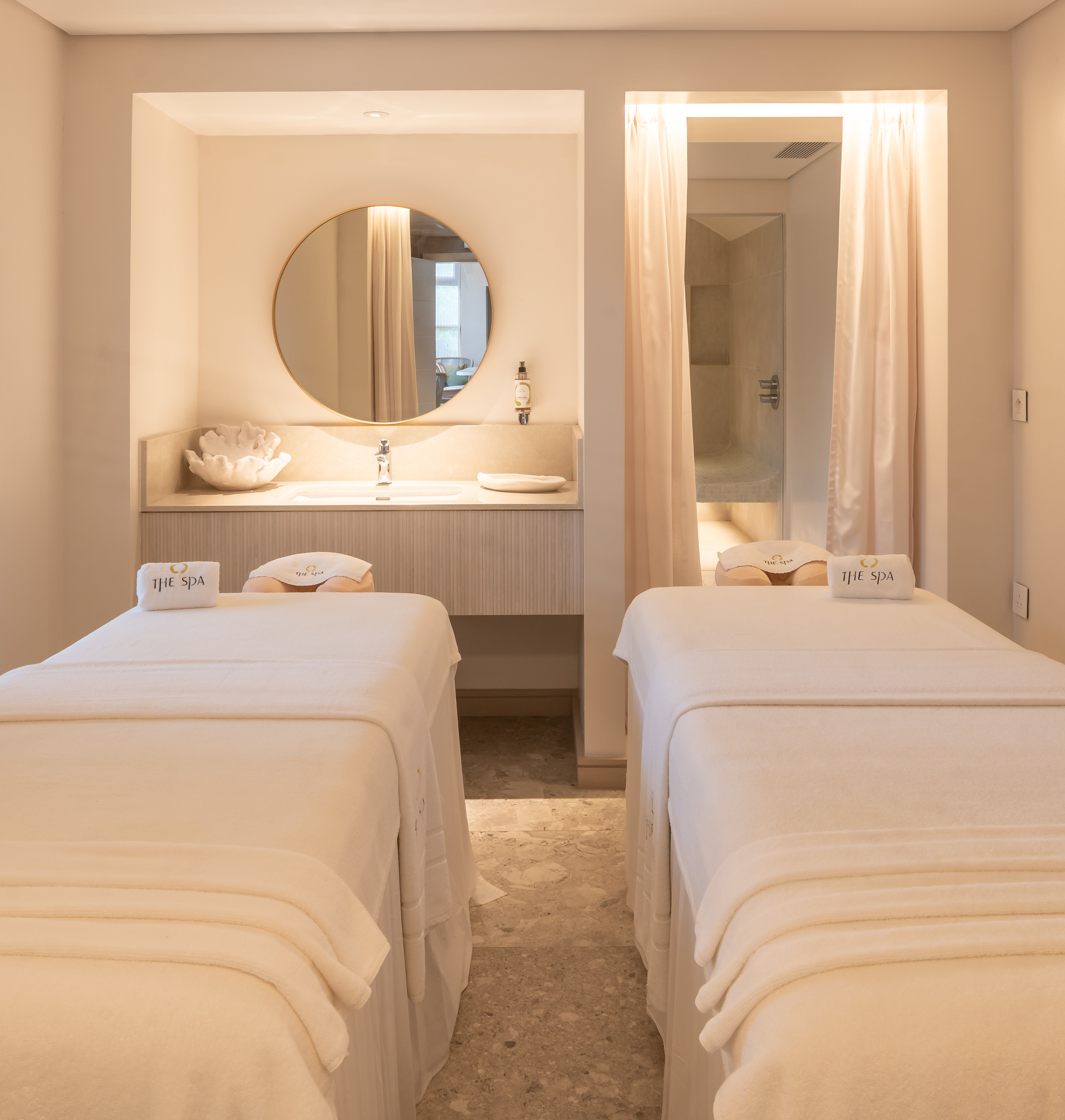 Tables de soins de spa dans une chambre avec miroir et vasque