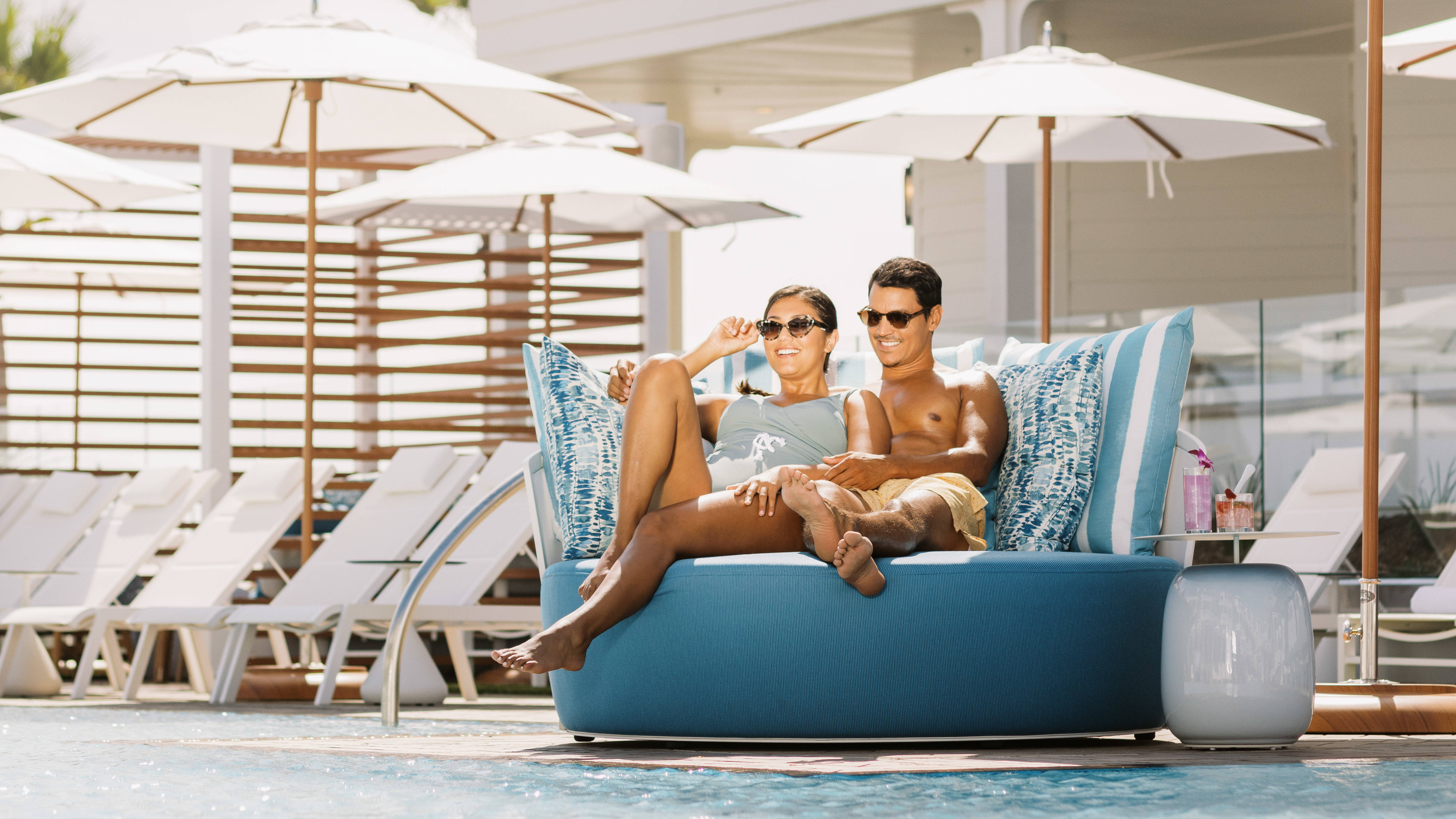 couple sitting in outdoor lounge area by pool