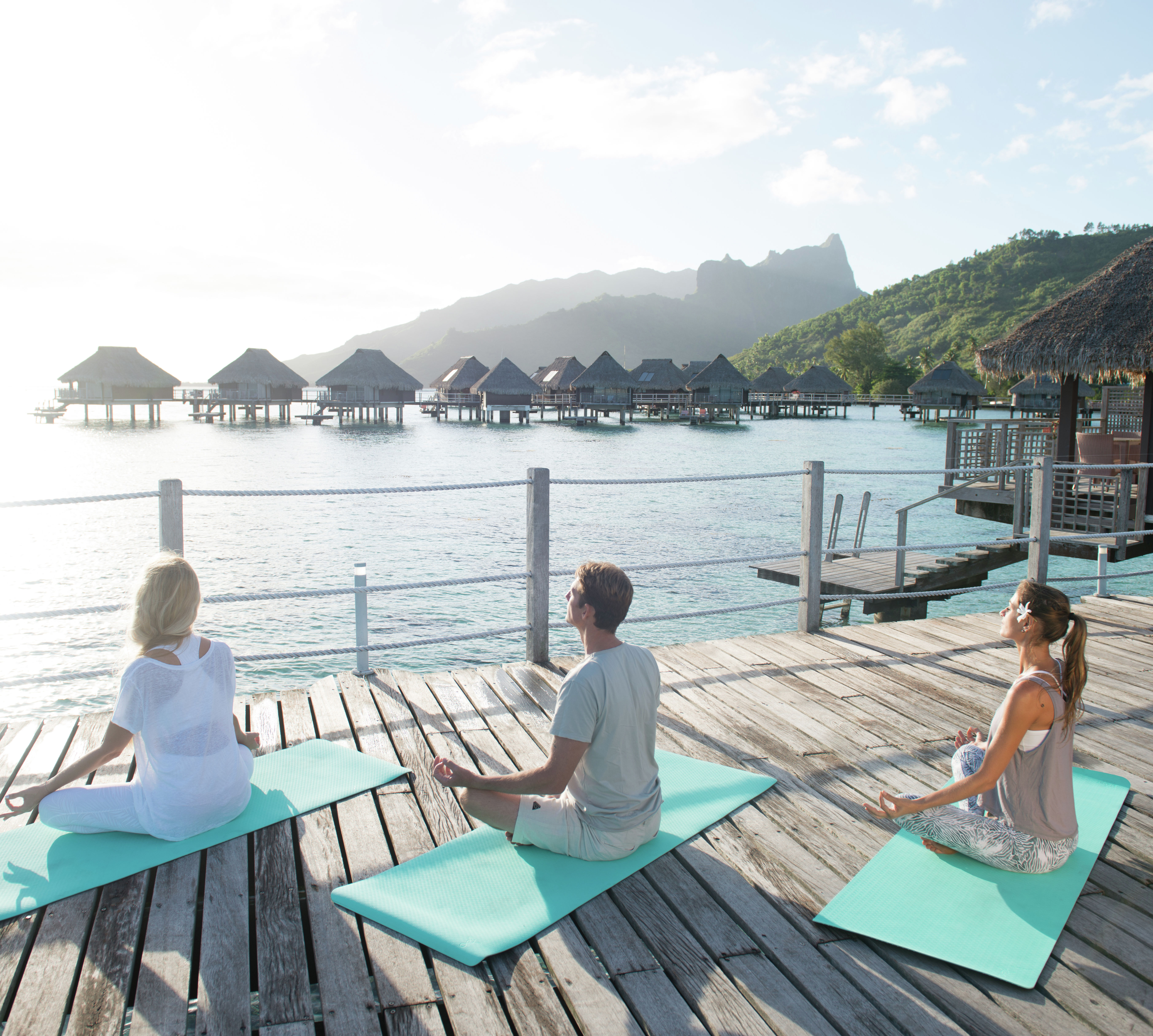 海を眺めながらヨガを楽しむ人々