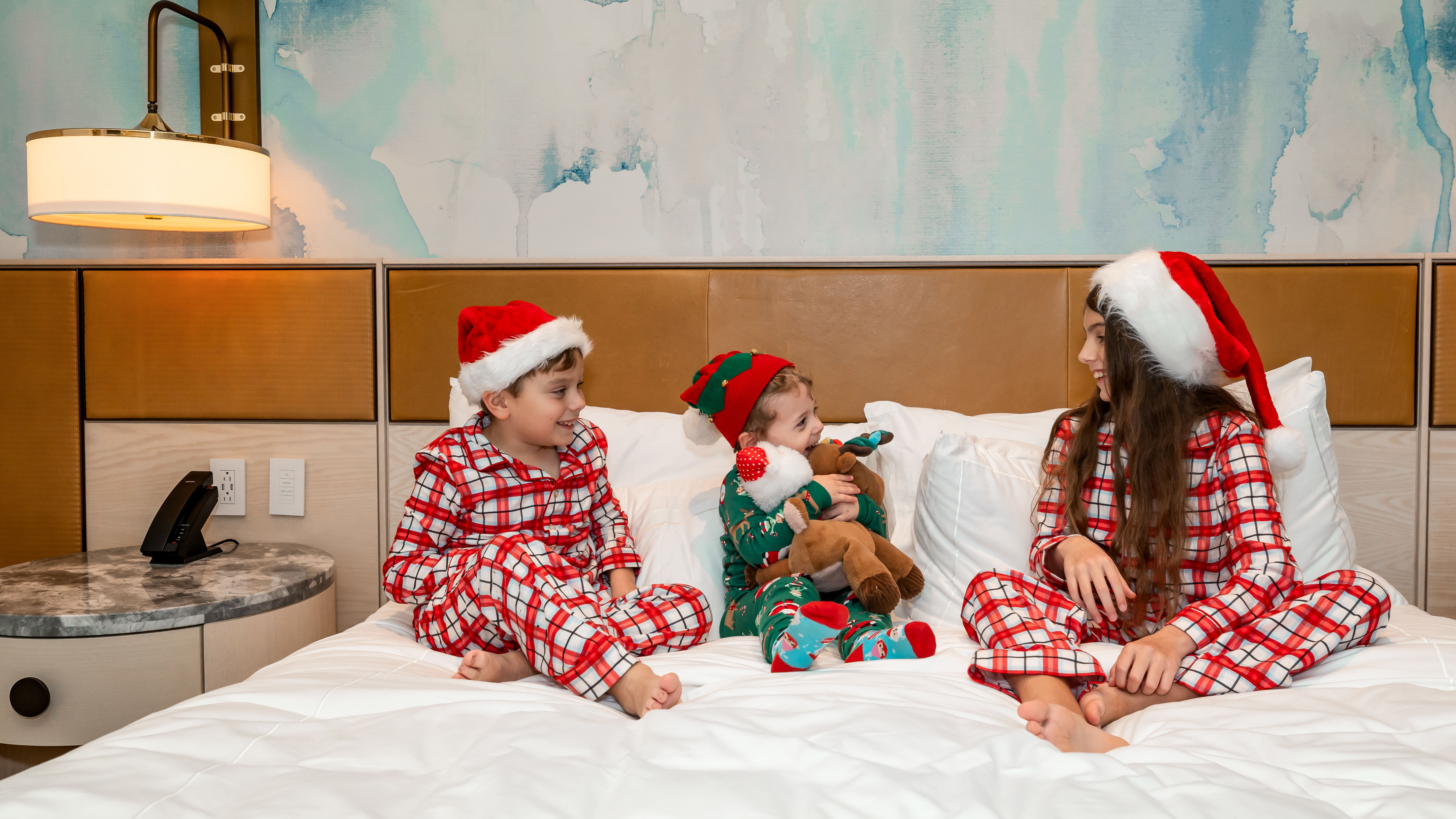 Kids in Christmas pajamas on bed